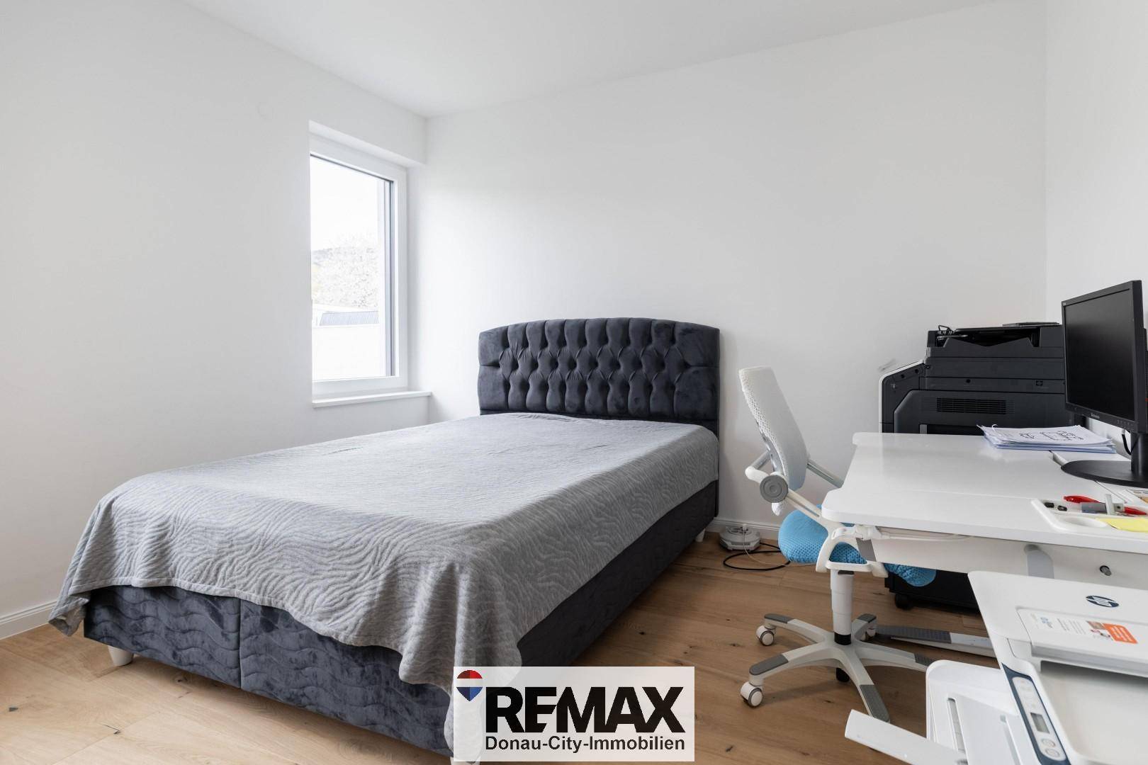 Helles Schlafzimmer mit Einzelbett, Schreibtisch und Fenster für natürliches Licht.