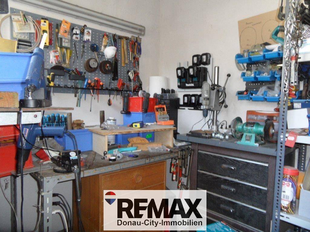 Gut ausgestattete Werkstatt mit verschiedenen Werkzeugen, Werkbänken und Maschinen für handwerkliche Arbeiten.