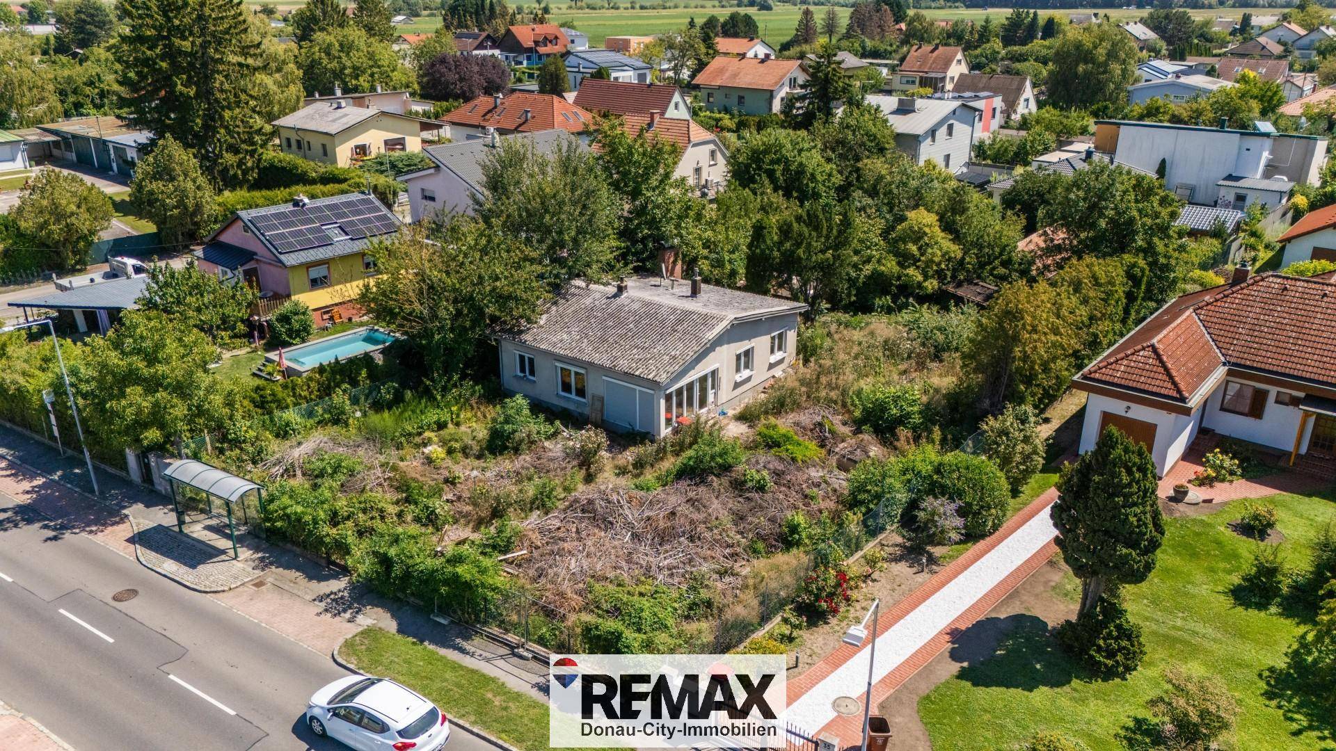 Luftaufnahme des Hauses mit weitläufigem Garten, Straße und Blick in die Ferne.