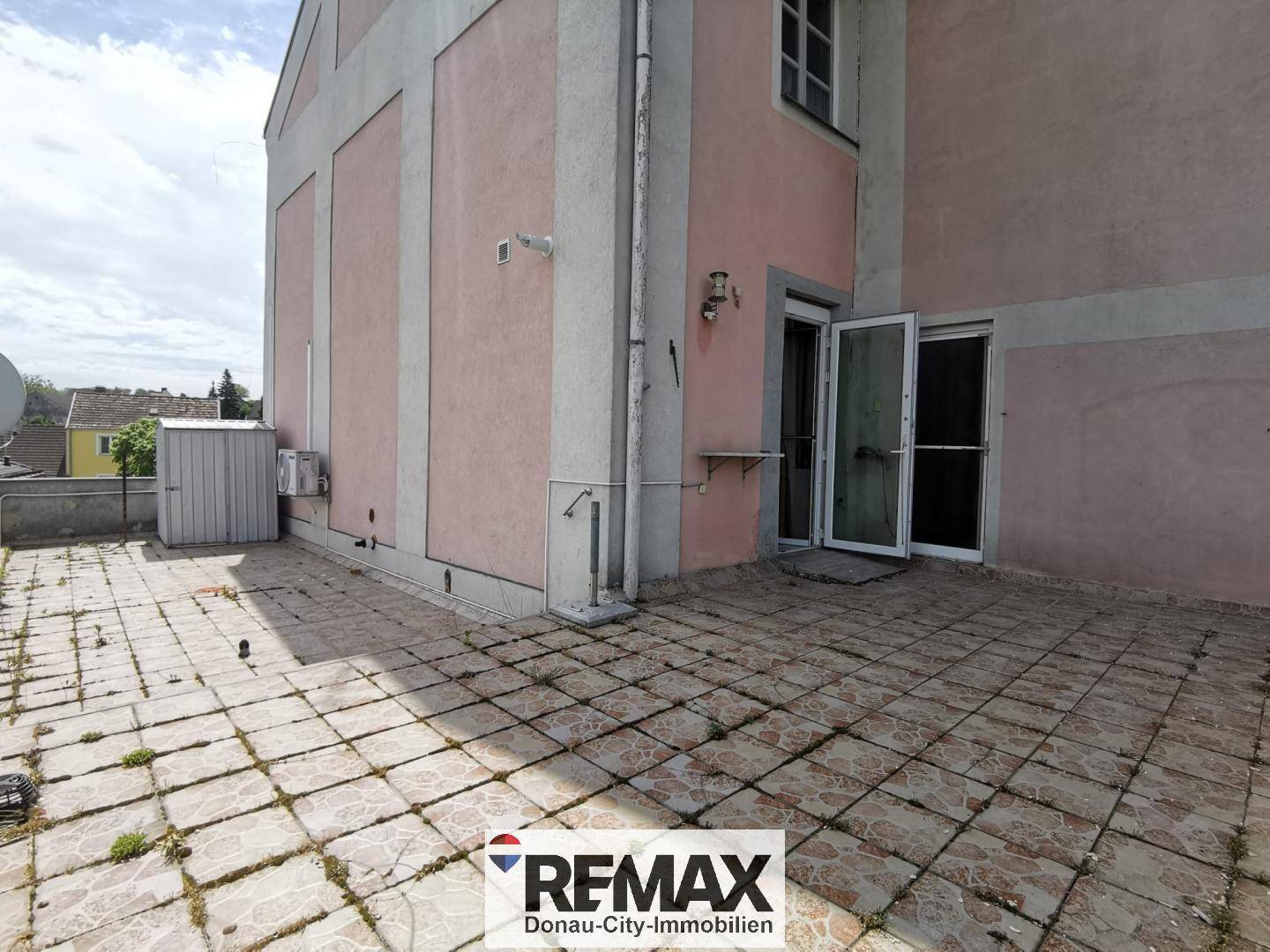 Weitere Ansicht der großen Terrasse mit Zugang zum Gebäude und Fliesenboden.