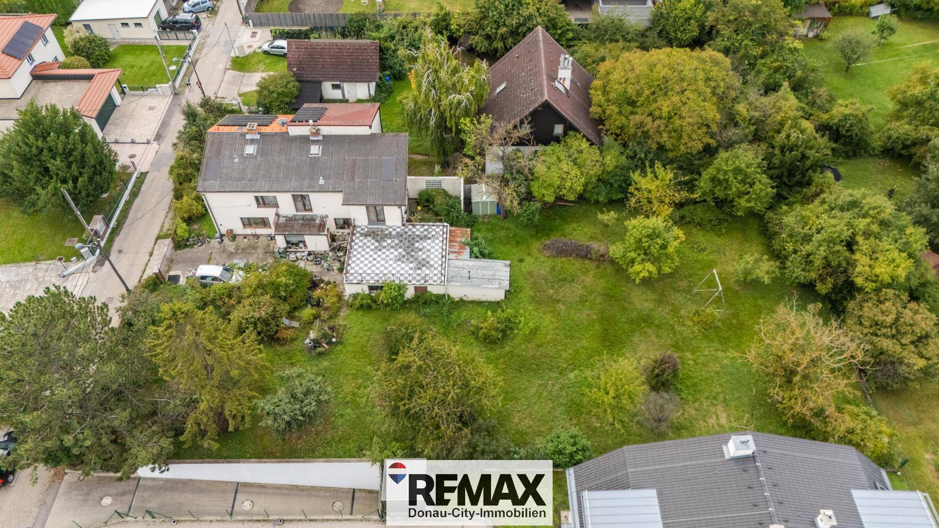 Weitläufige Luftaufnahme des Anwesens mit Wohnhaus, großem Garten und umliegender Wohngegend.