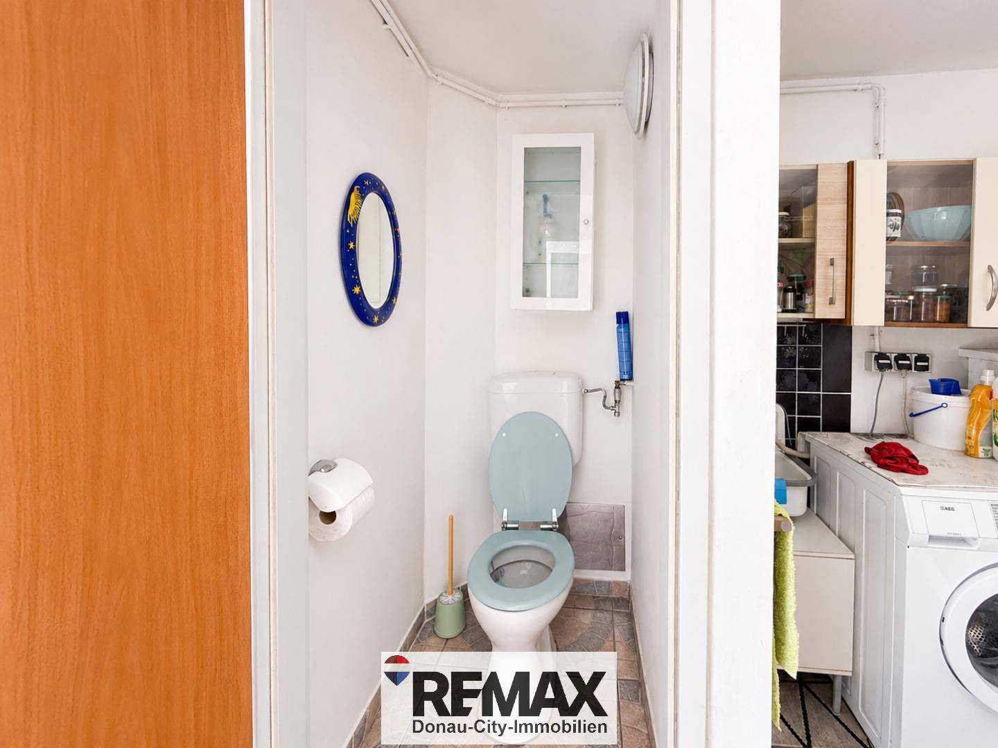 Kleines Gäste-WC mit Toilette und kleinem Spiegelschrank.