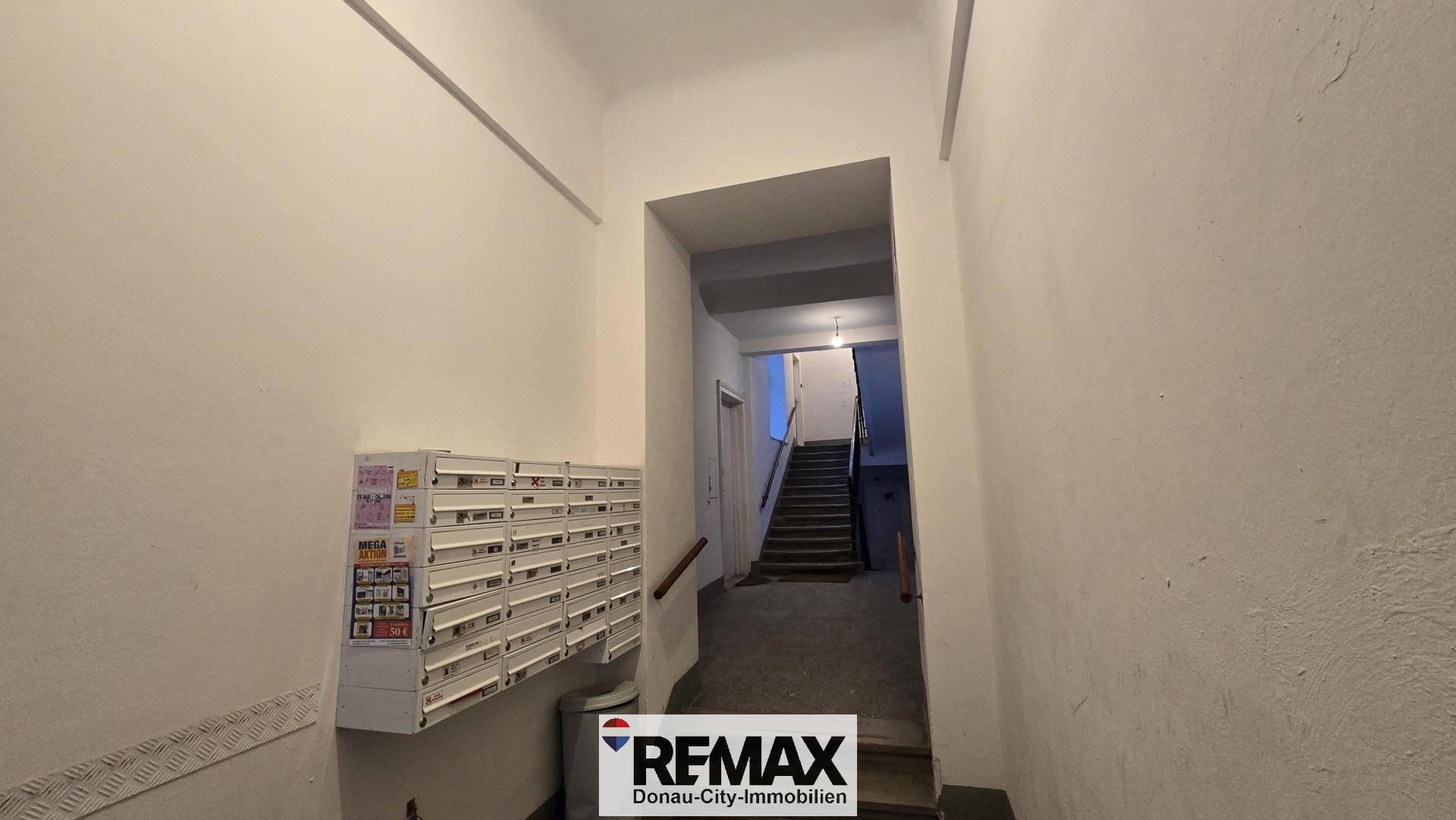 Eingangsbereich mit Briefkästen und Treppenaufgang in einem Mehrfamilienhaus.