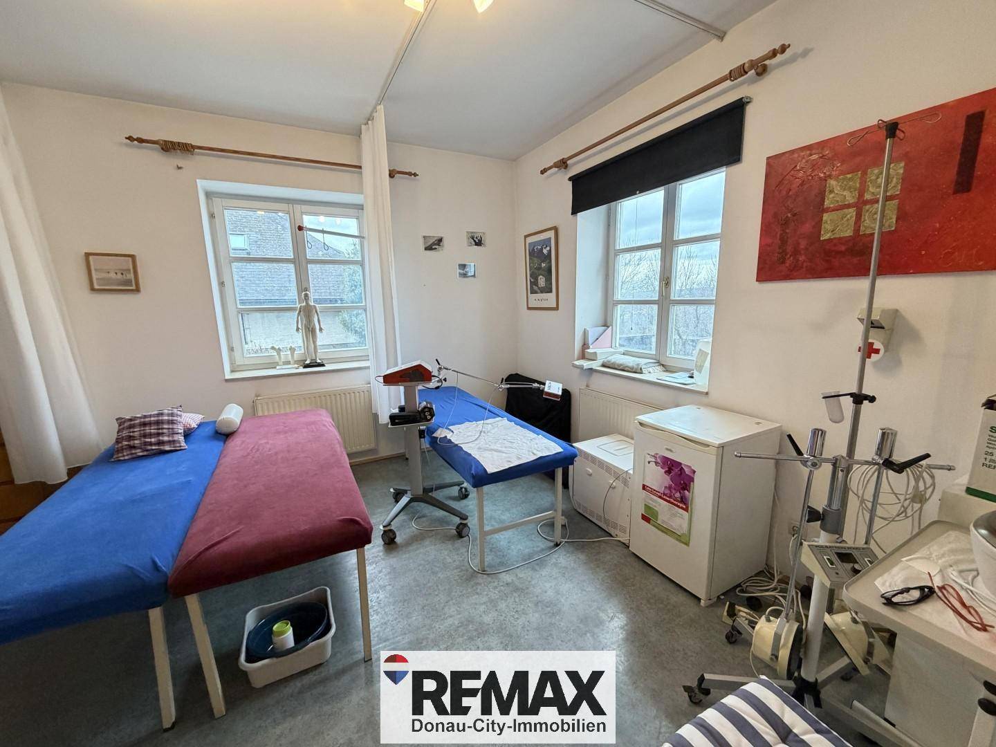 Weiterer Blick in den Behandlungsraum mit medizinischer Ausrüstung und Vinylboden.