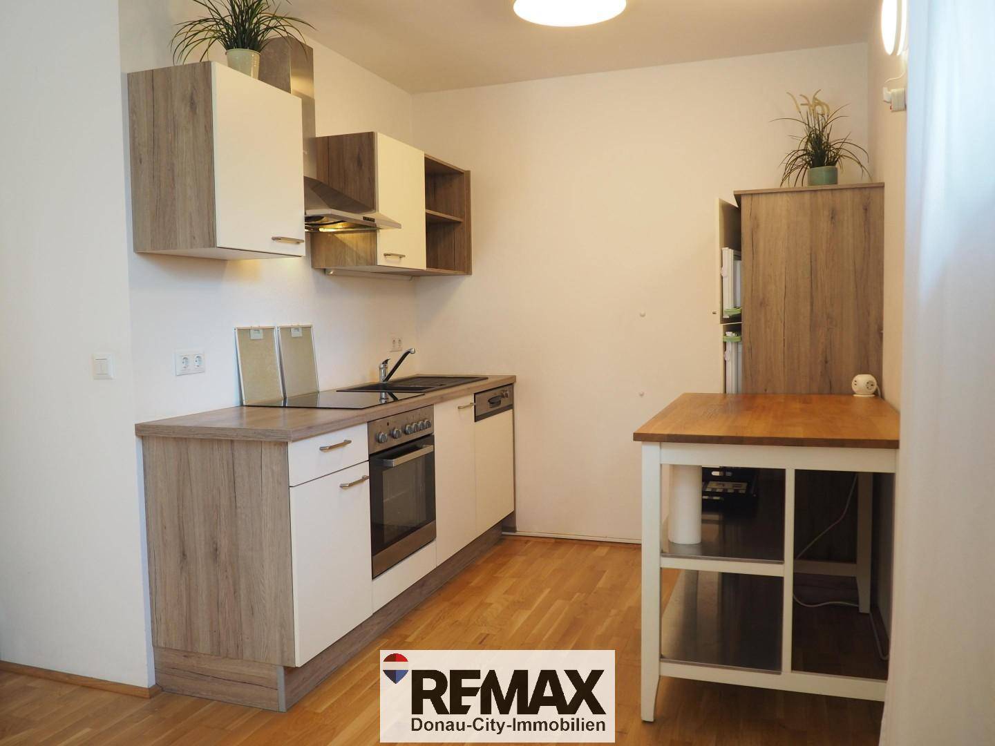 Moderne Küchenzeile mit Holz- und weißen Fronten, ausgestattet mit Einbaugeräten.