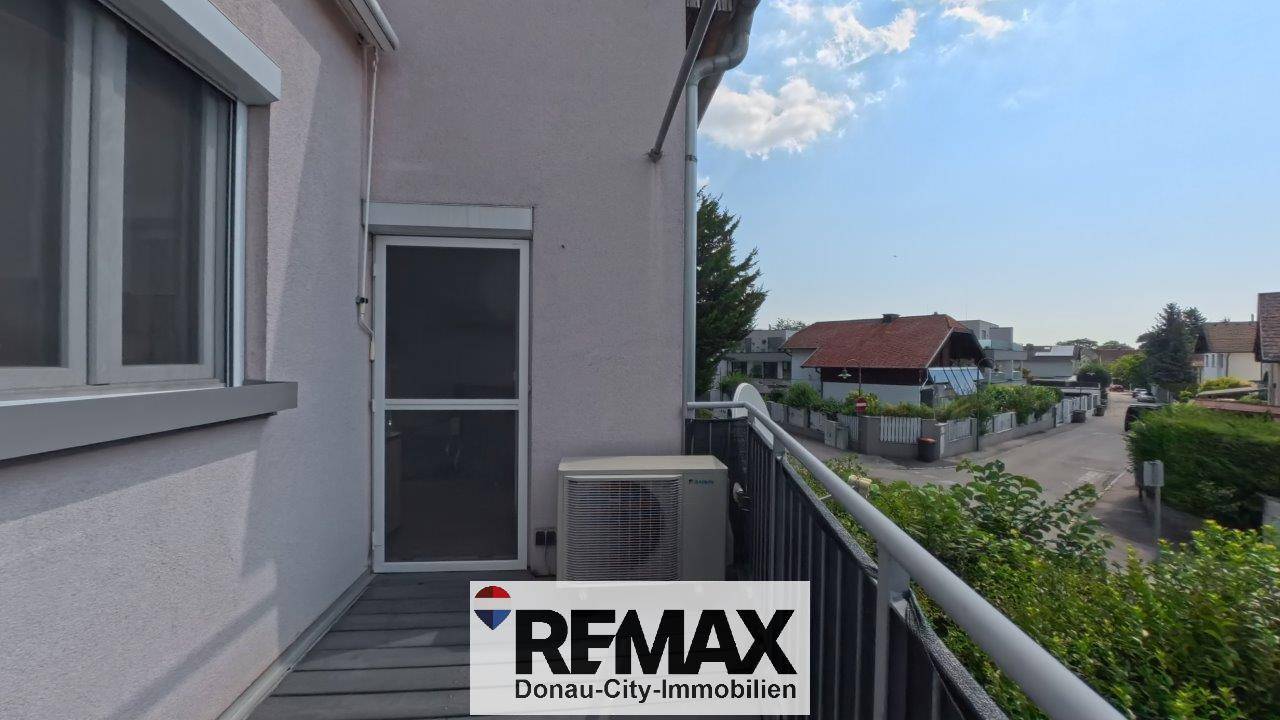 Balkon mit Klimaanlage und Blick auf die umliegende Nachbarschaft.