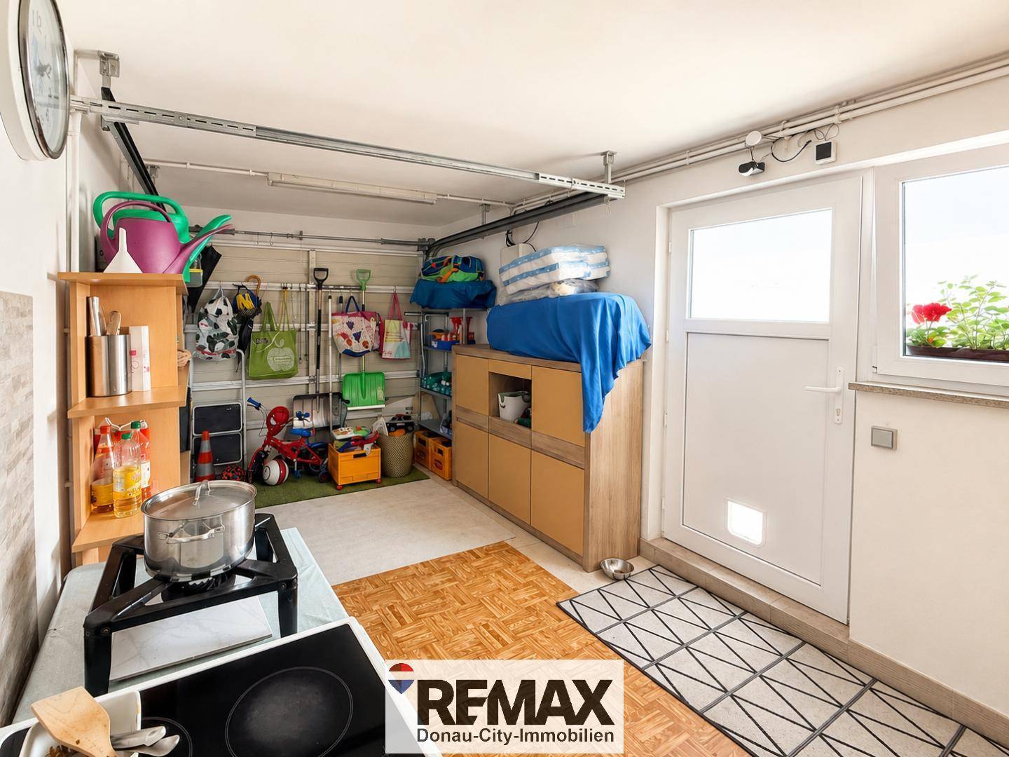 Helle Garage mit Fenster, Stauraum und Zugang zum Außenbereich.