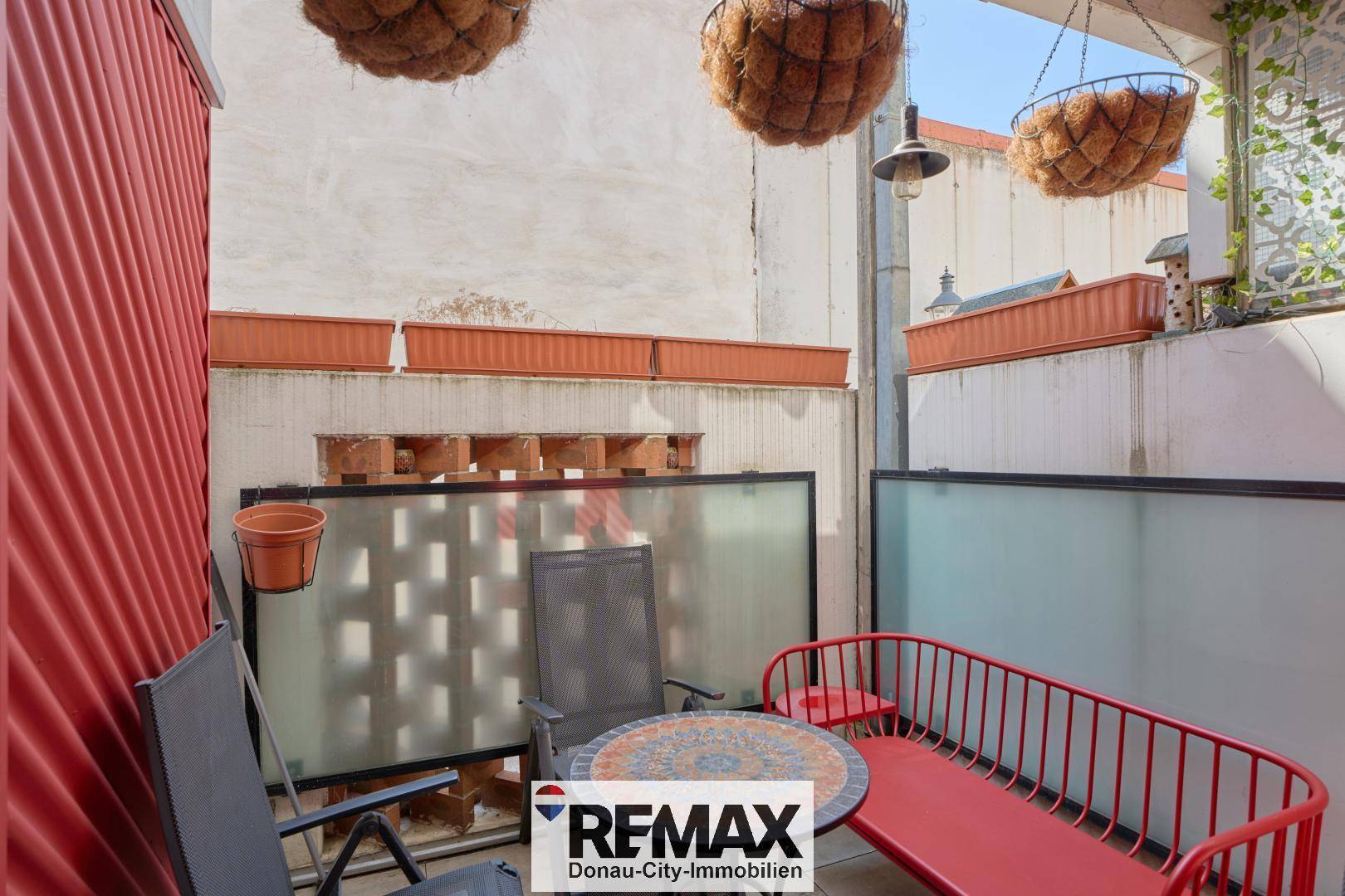 Kleiner, gemütlicher Balkon mit Sitzgelegenheiten und Pflanzen.