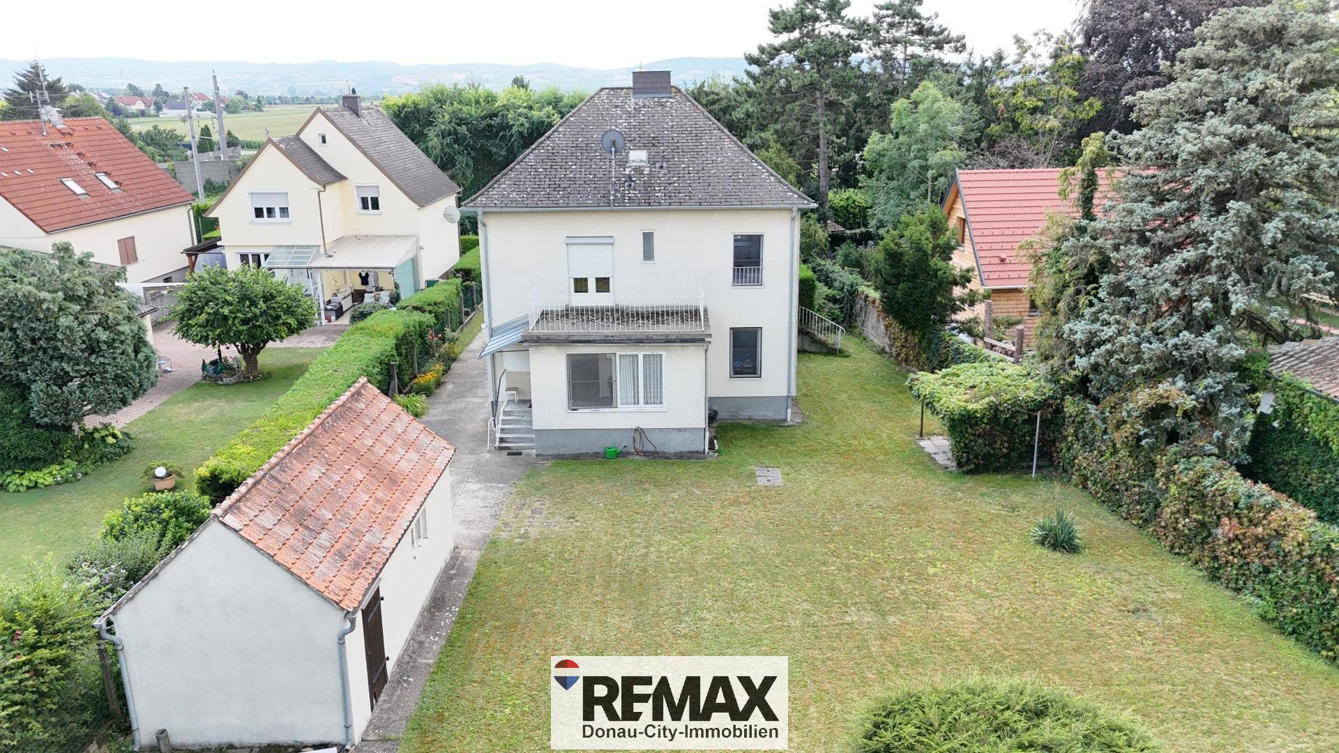 Luftaufnahme der Rückseite des Hauses mit großem Garten und Nebengebäude.