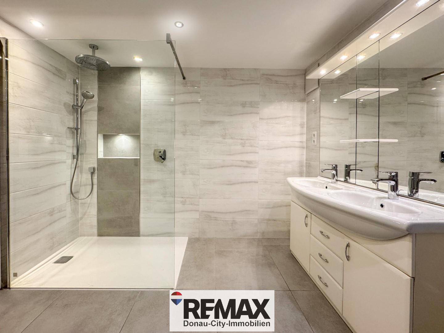 Großes modernes Badezimmer mit Doppelwaschbecken, begehbarer Dusche und Spiegelschrank.