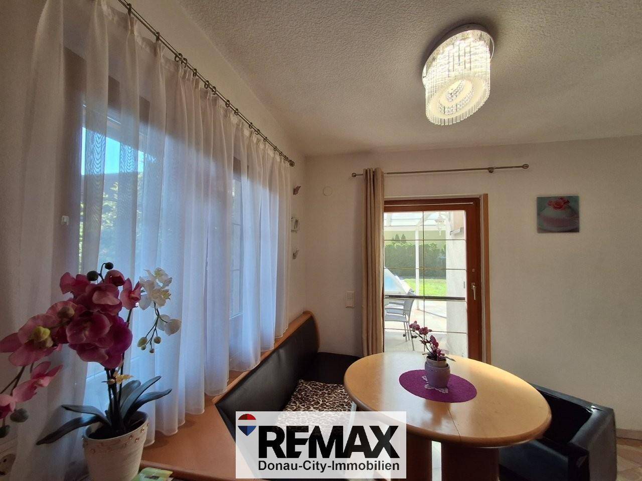 Gemütliche Essecke mit rundem Tisch und Fenster, das viel Tageslicht in den Raum lässt.