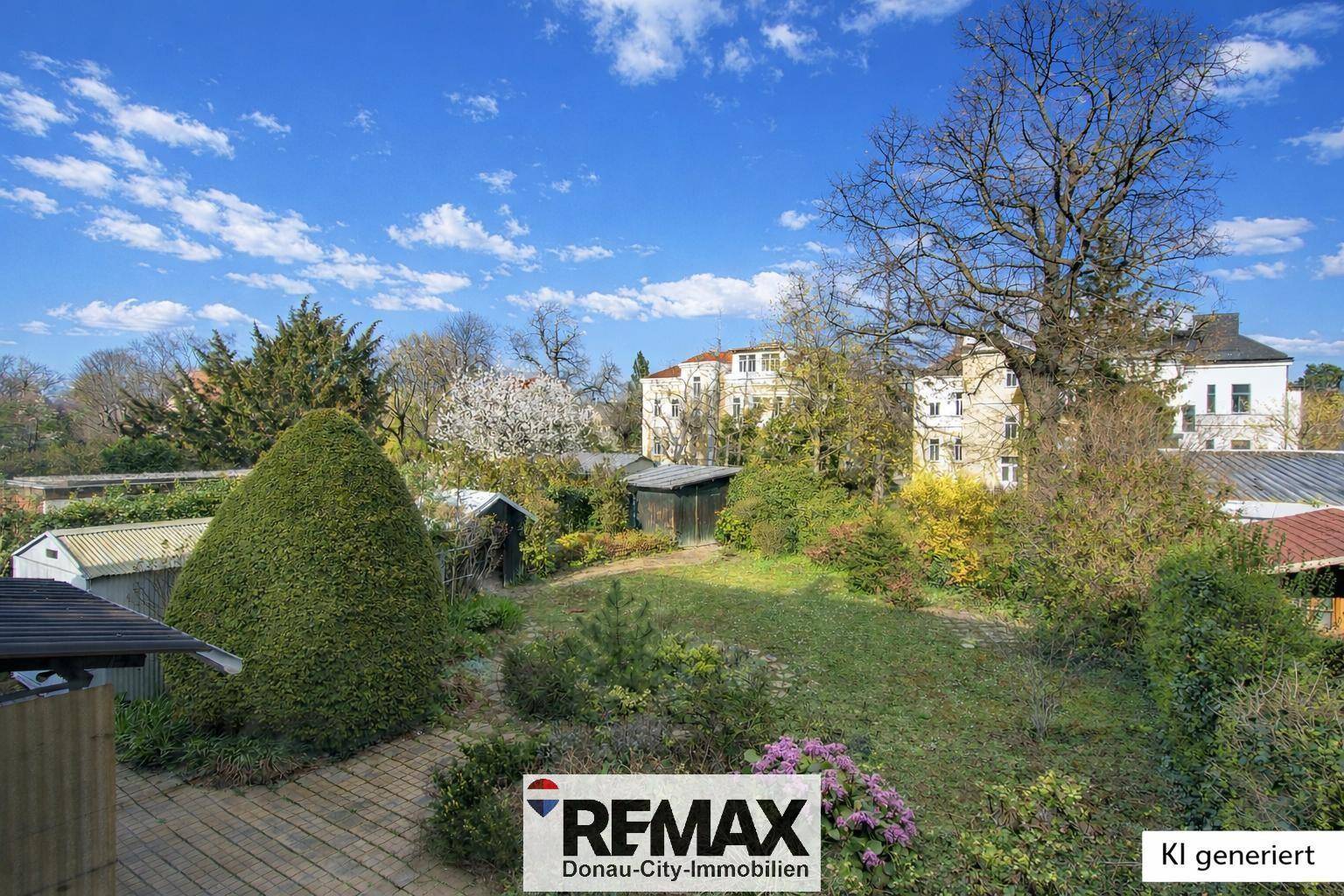 Weitläufiger Garten mit altem Baumbestand und Blick auf die umliegenden Gebäude.