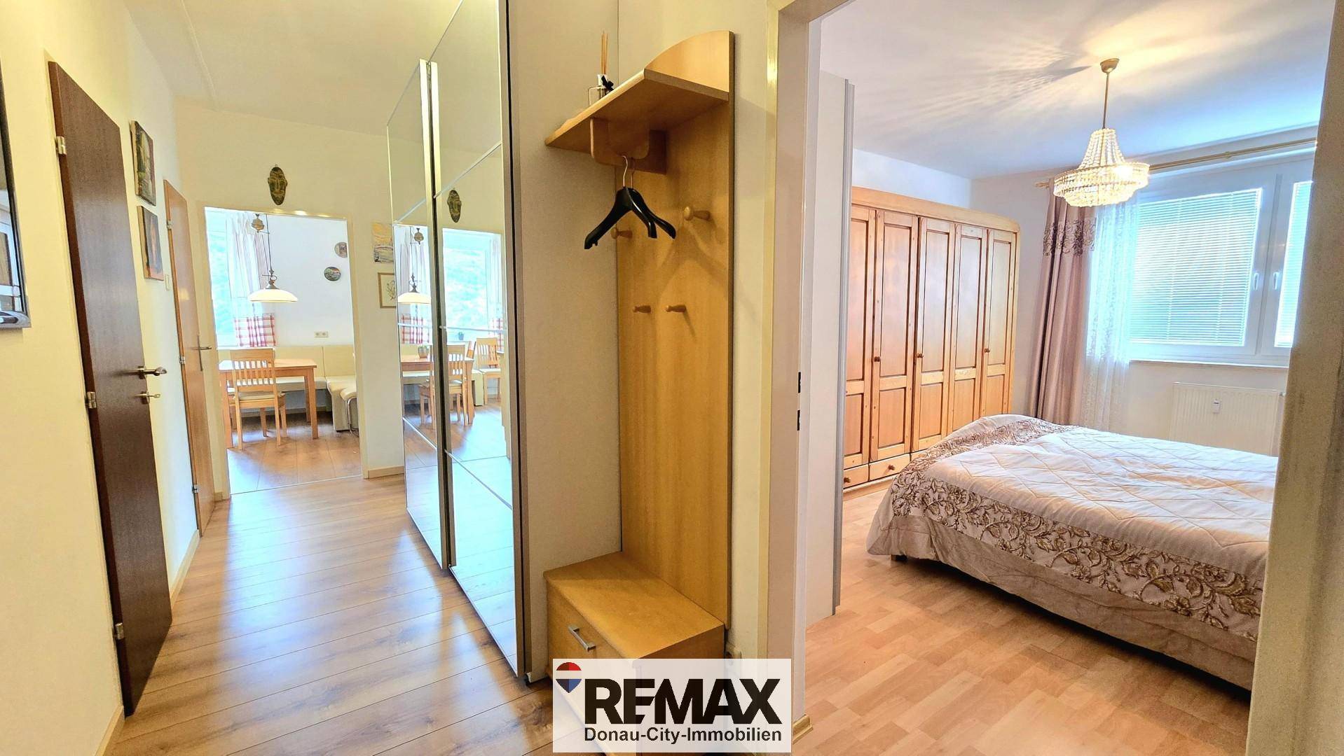 Flur mit Garderobe und Blick in ein Schlafzimmer, das eine gemütliche Atmosphäre bietet.