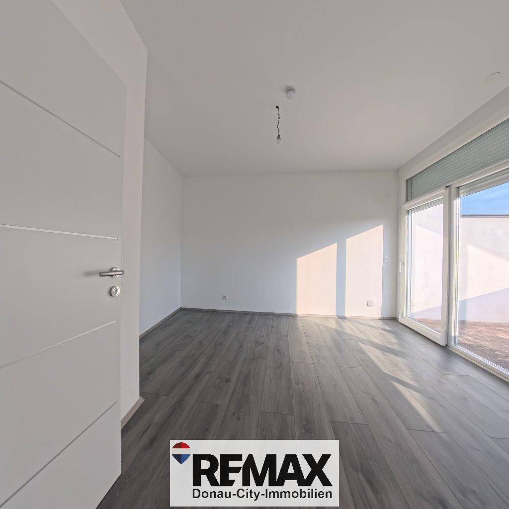 Geräumiges Zimmer mit Laminatboden und großen Fenstern, ideal als Schlaf- oder Arbeitszimmer.
