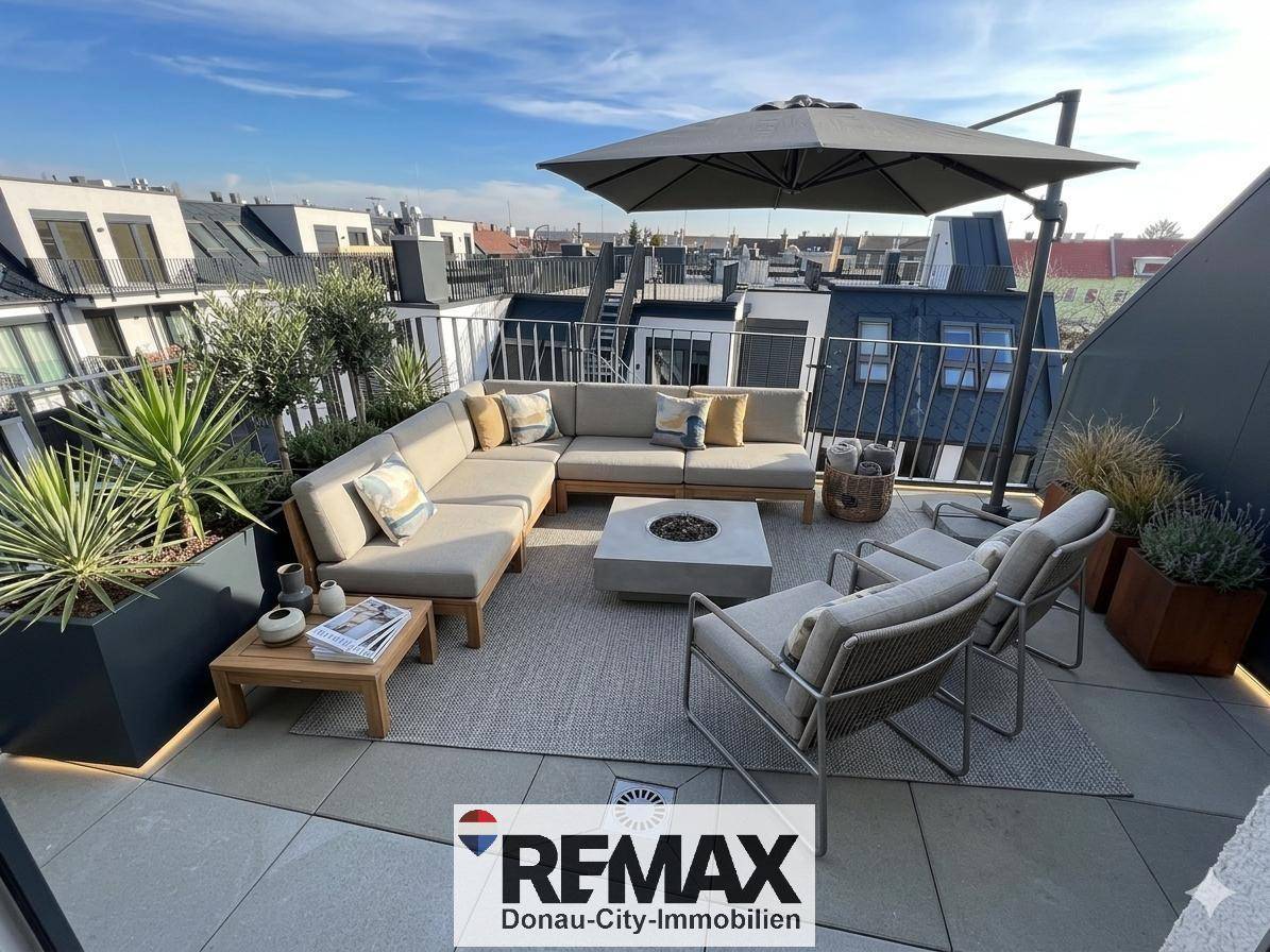 Große, möblierte Dachterrasse mit Lounge-Möbeln und Sonnenschirm, perfekt für Entspannung im Freien.