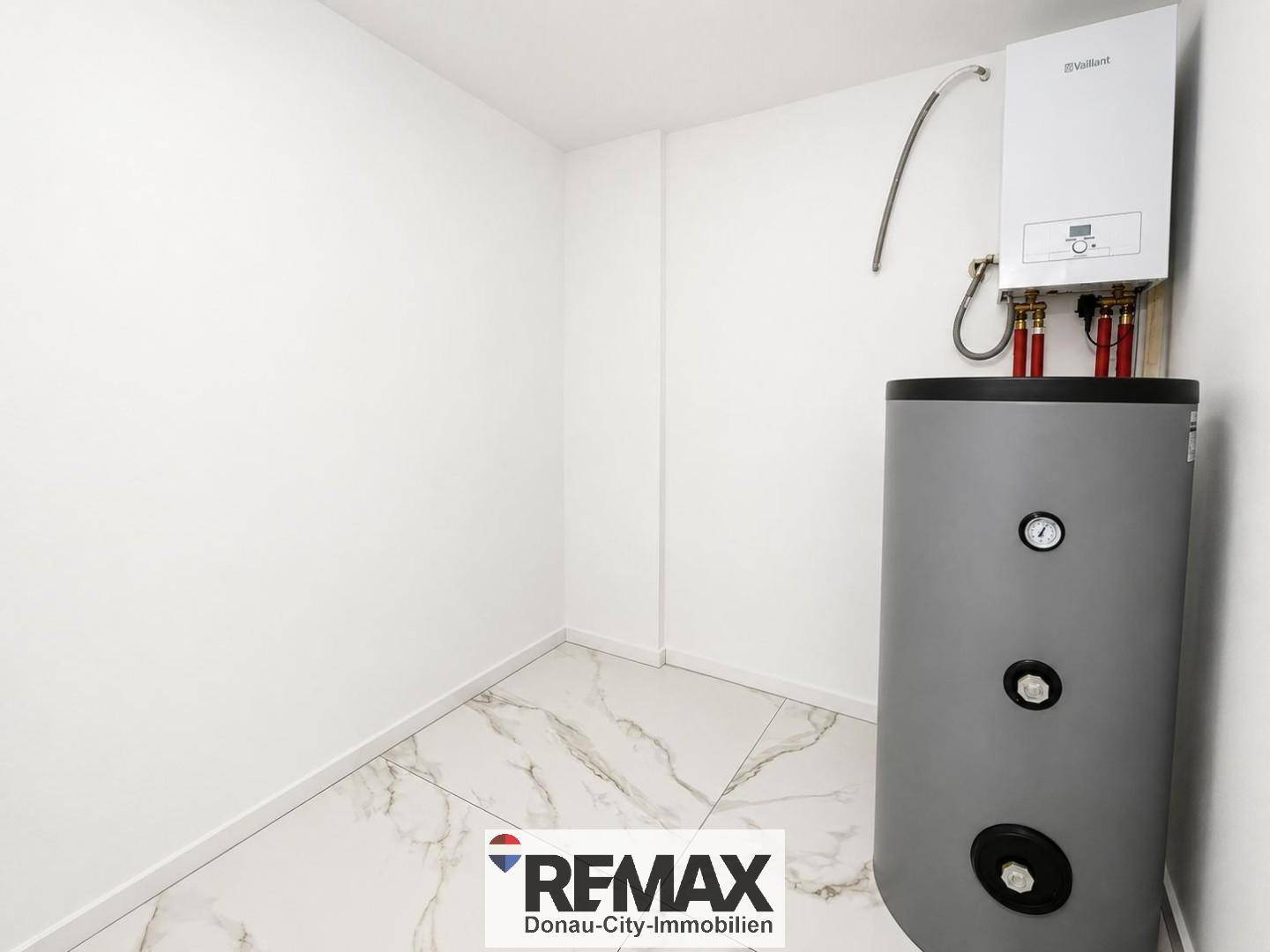 Praktischer Hauswirtschaftsraum mit Warmwasserbereiter und Boiler auf gefliestem Boden.