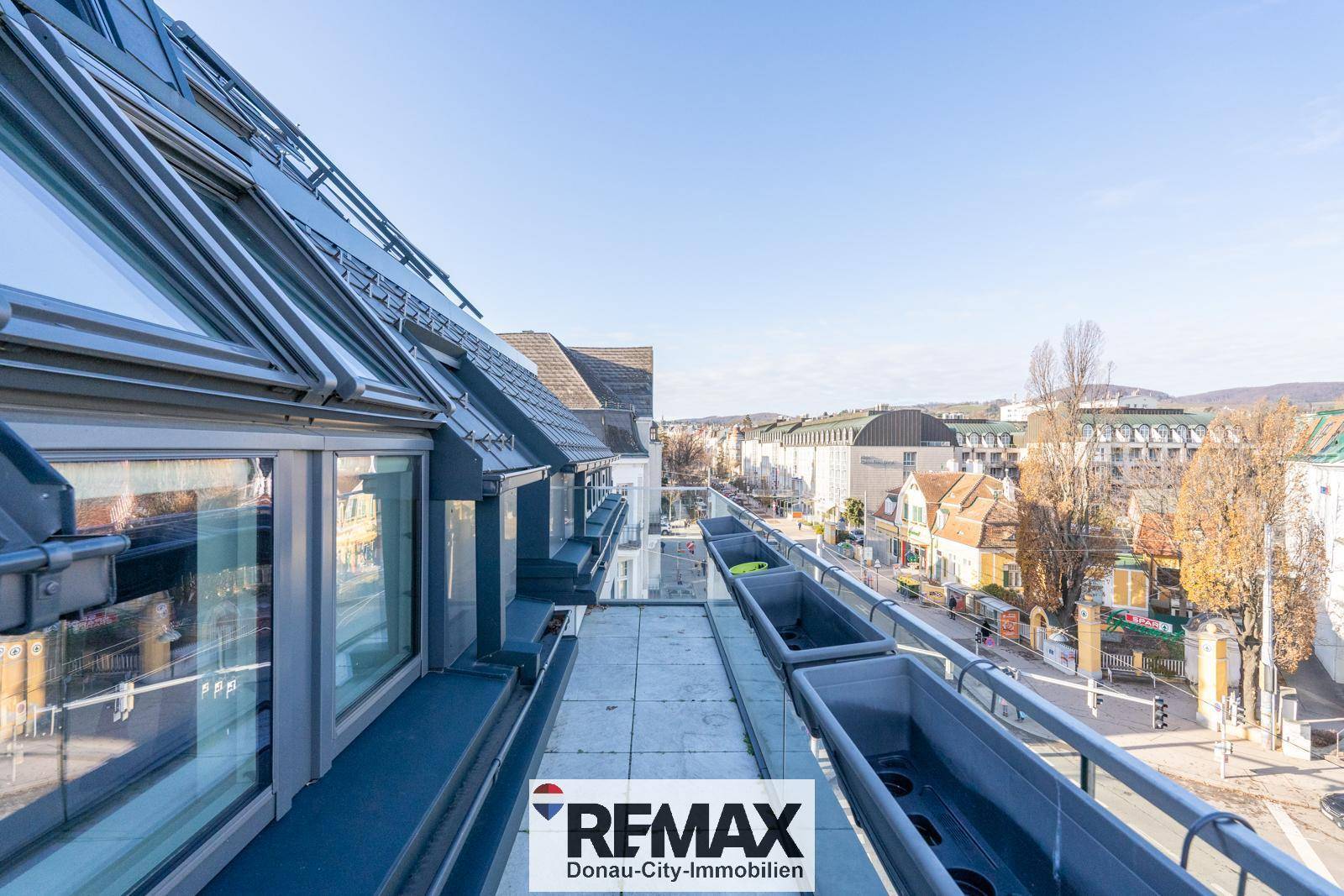 Dachterrasse mit Pflanzgefäßen und Panoramablick über die Stadtlandschaft.