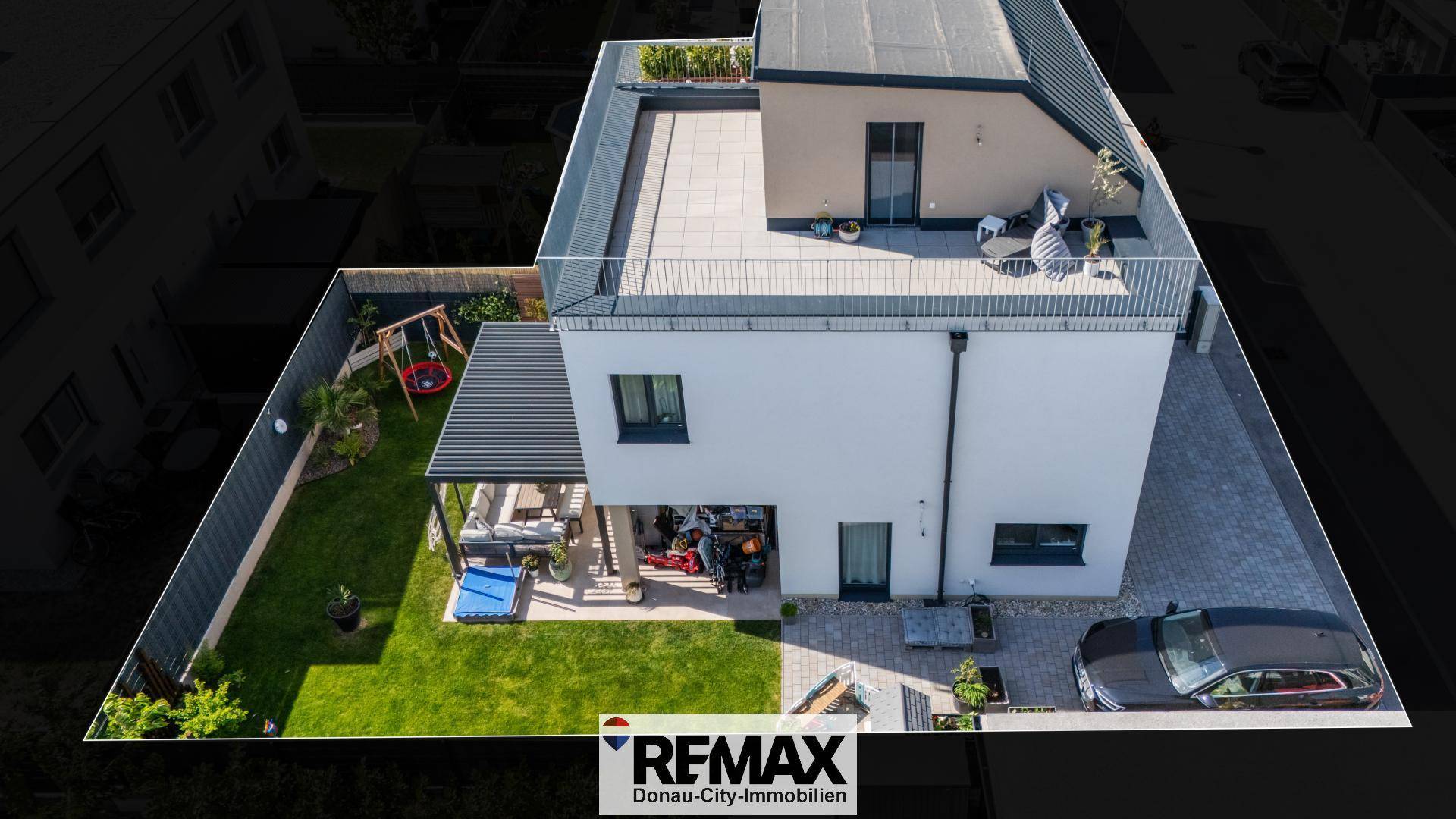 Vogelperspektive des modernen Hauses mit Garten, Terrasse und Dachterrasse.
