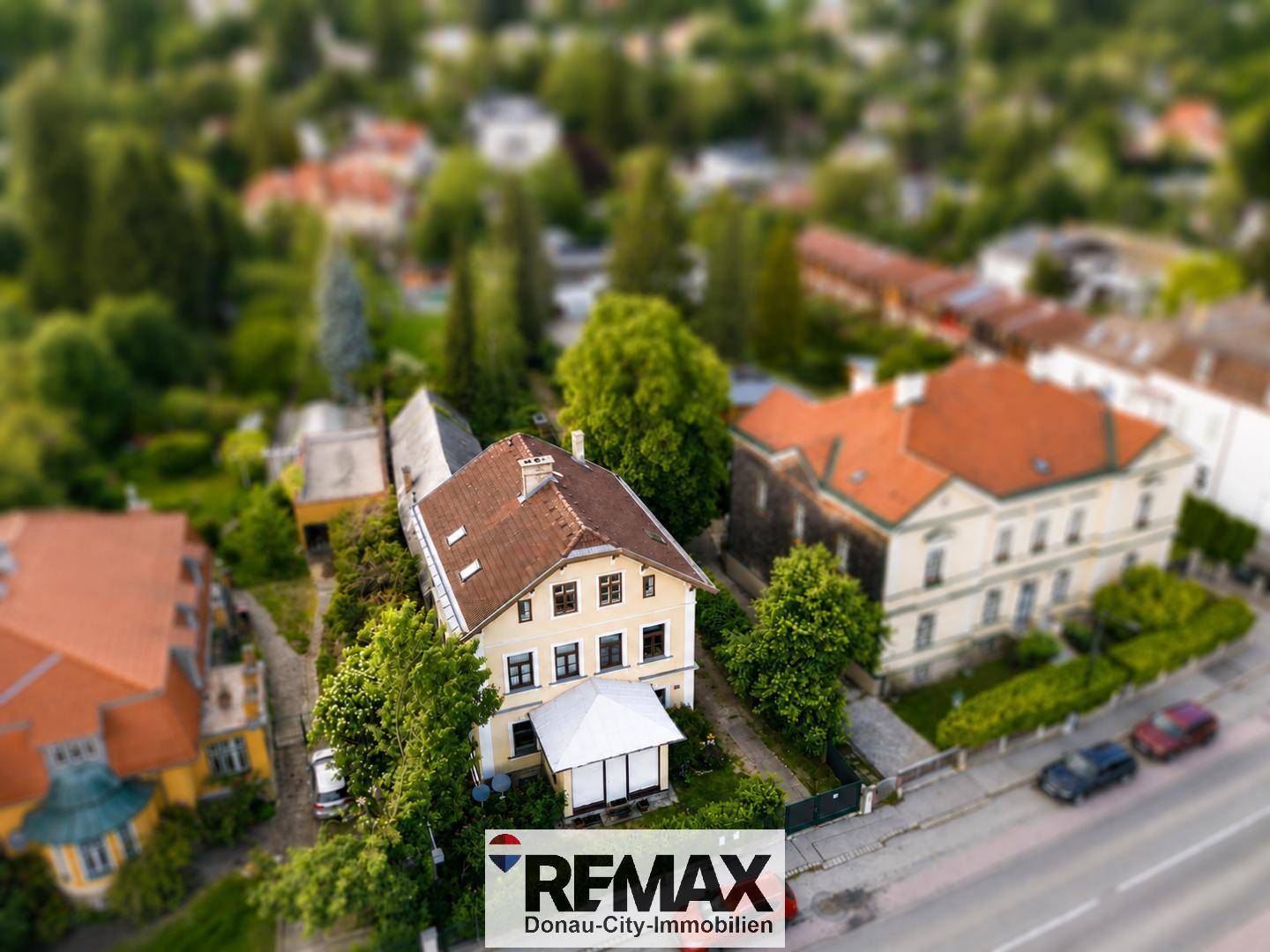 Miniaturisierte Luftaufnahme eines Hauses mit umliegender Straße und grüner Umgebung.
