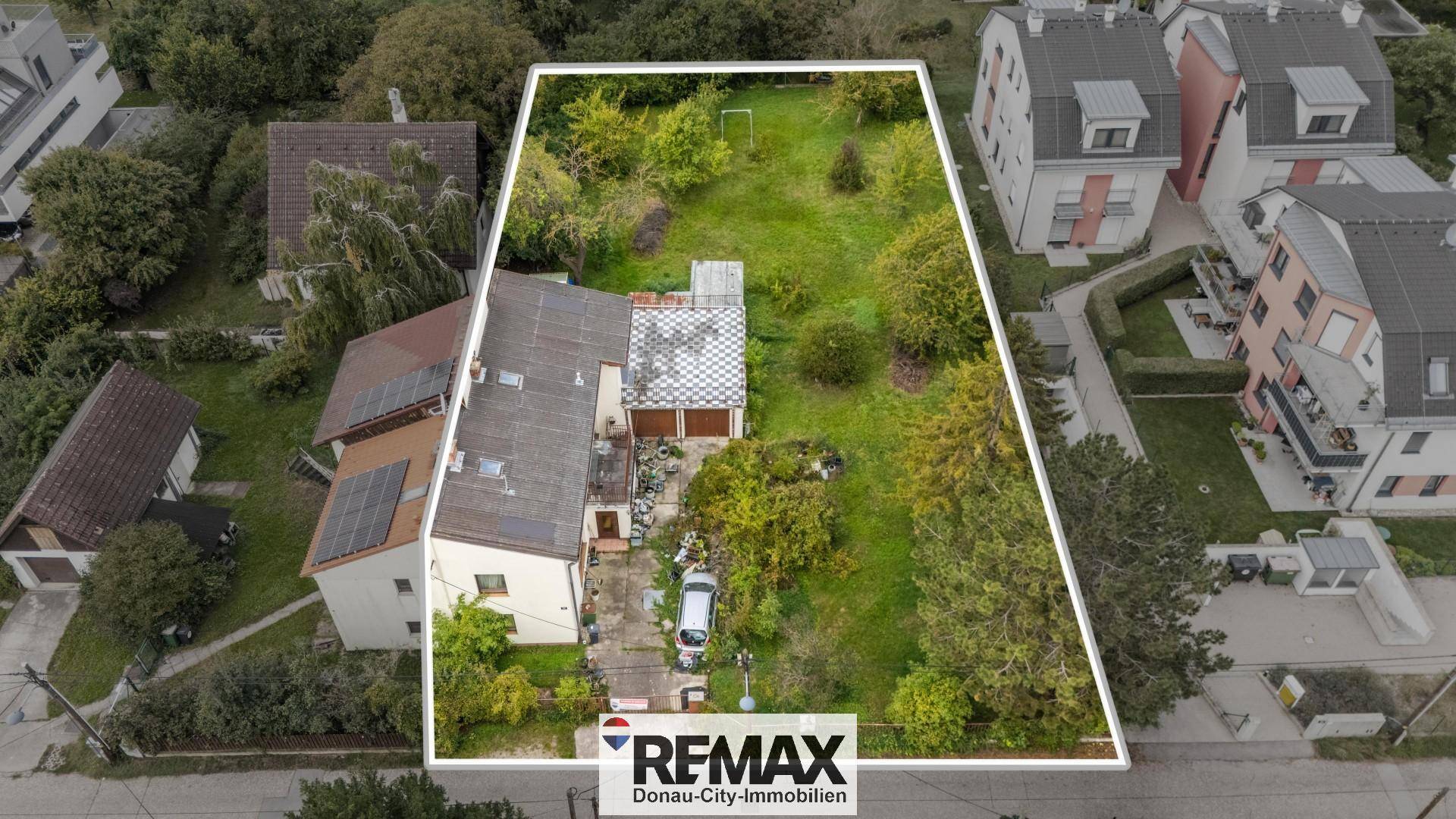 Luftaufnahme des Grundstücks mit Wohnhaus, Solaranlagen und großem Garten, umrandet von einer Markierung.