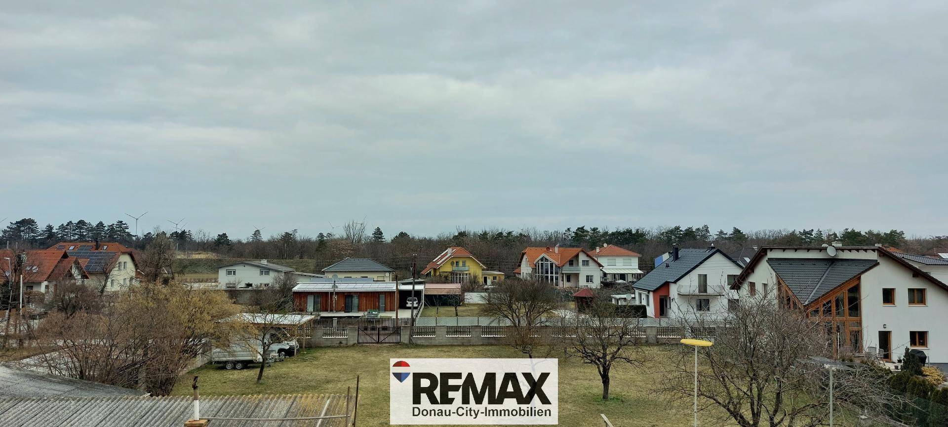 Panoramablick über eine Wohnsiedlung mit viel Grün und Bäumen, idyllische Landschaft.