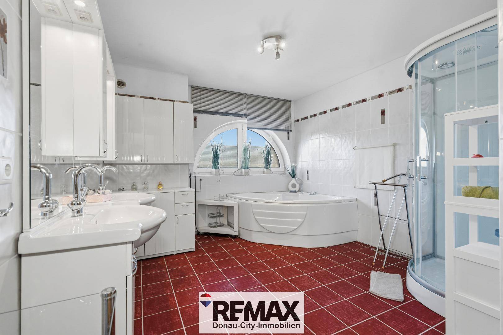 Großes Badezimmer mit Eckbadewanne, Duschkabine und Doppelwaschbecken.