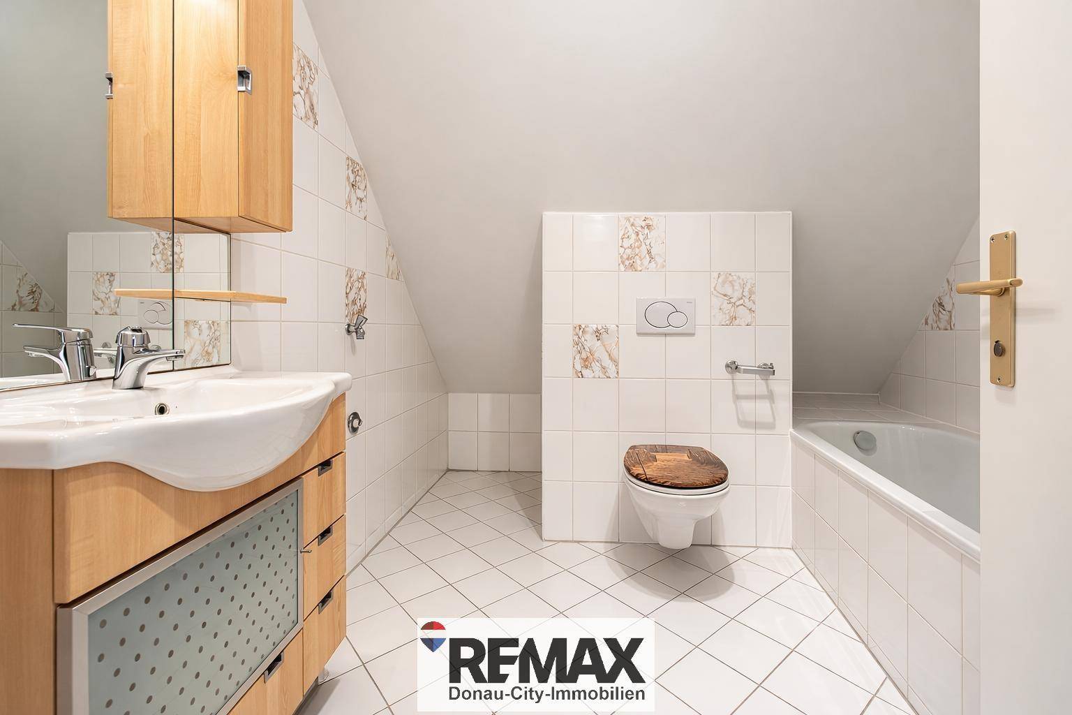 Geräumiges Badezimmer mit Badewanne, Waschbecken und Dachschräge.