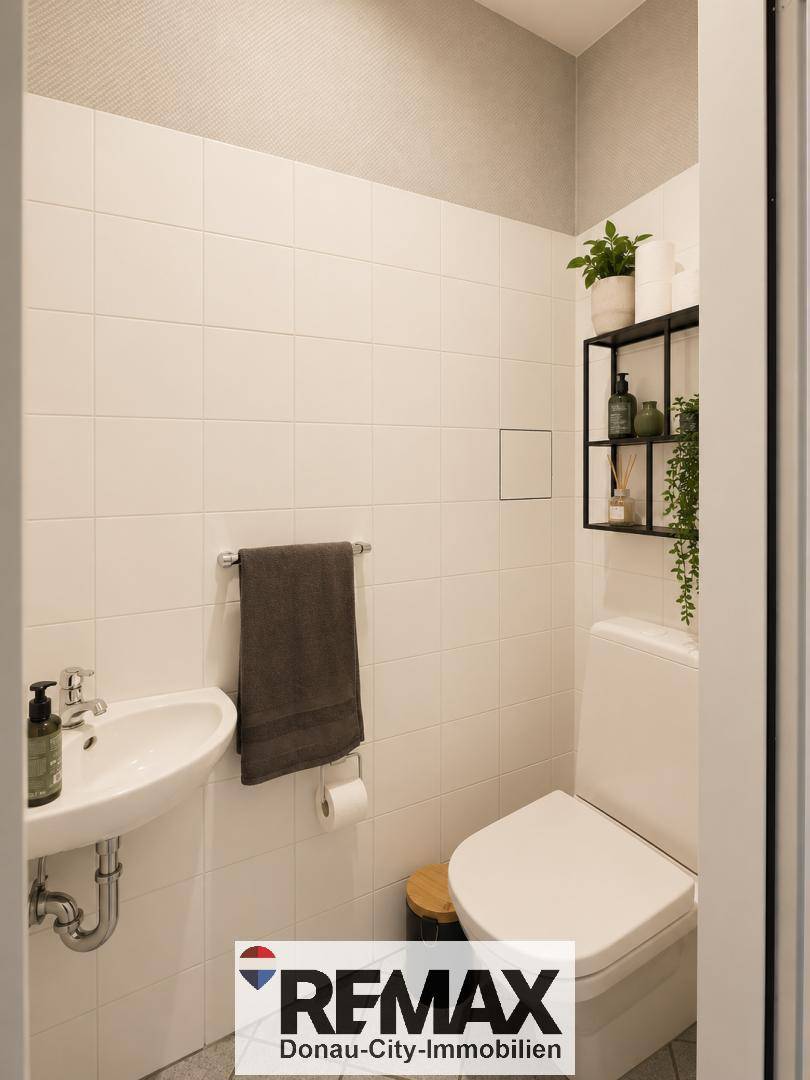 Modernes Gäste-WC mit weißen Fliesen, wandmontierter Toilette und kleinem Waschbecken.