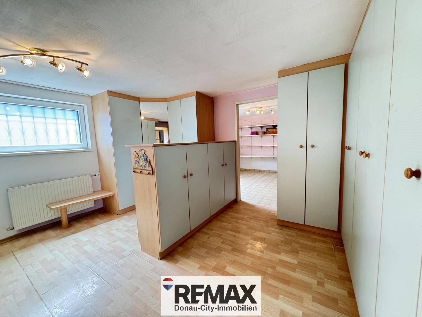 Raum mit Einbauschränken und Holzfußboden, möglicherweise als Ankleidezimmer oder Abstellraum genutzt.