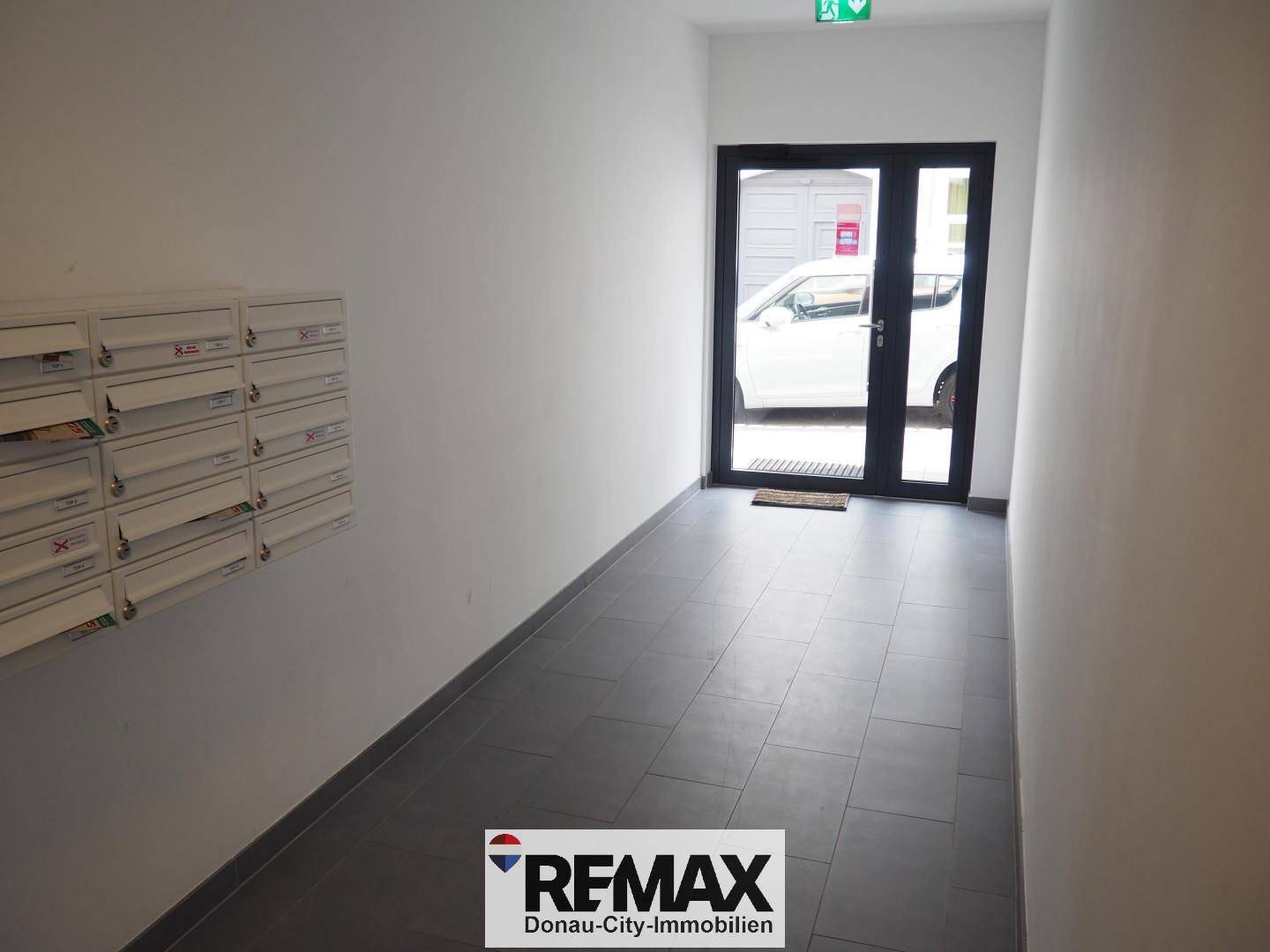 Eingangsbereich des Gebäudes mit Briefkästen und Zugang zur Straße.