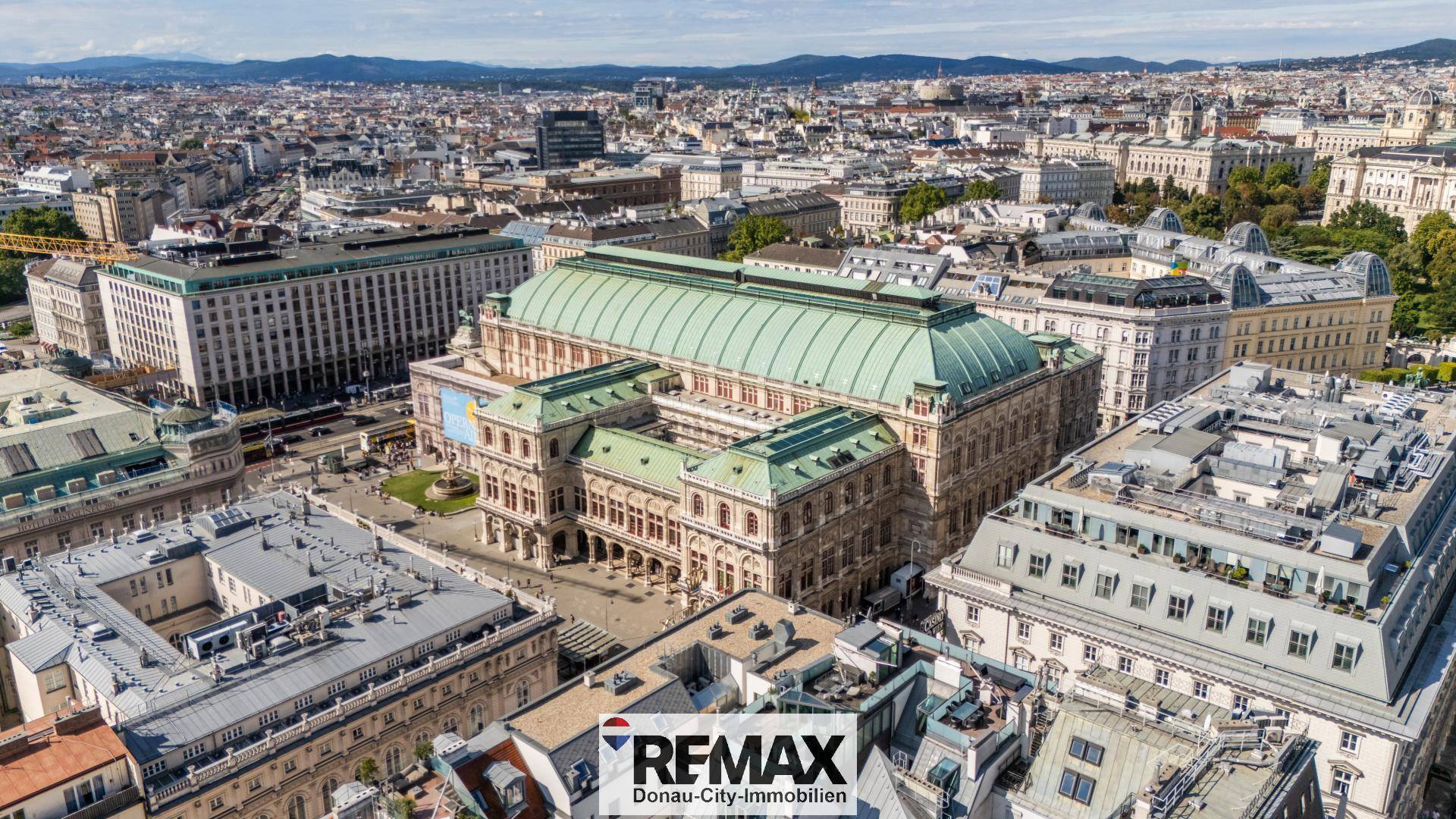 Luftaufnahme der Wiener Staatsoper und umliegender Gebäude, die die historische Architektur der Stadt zeigt.