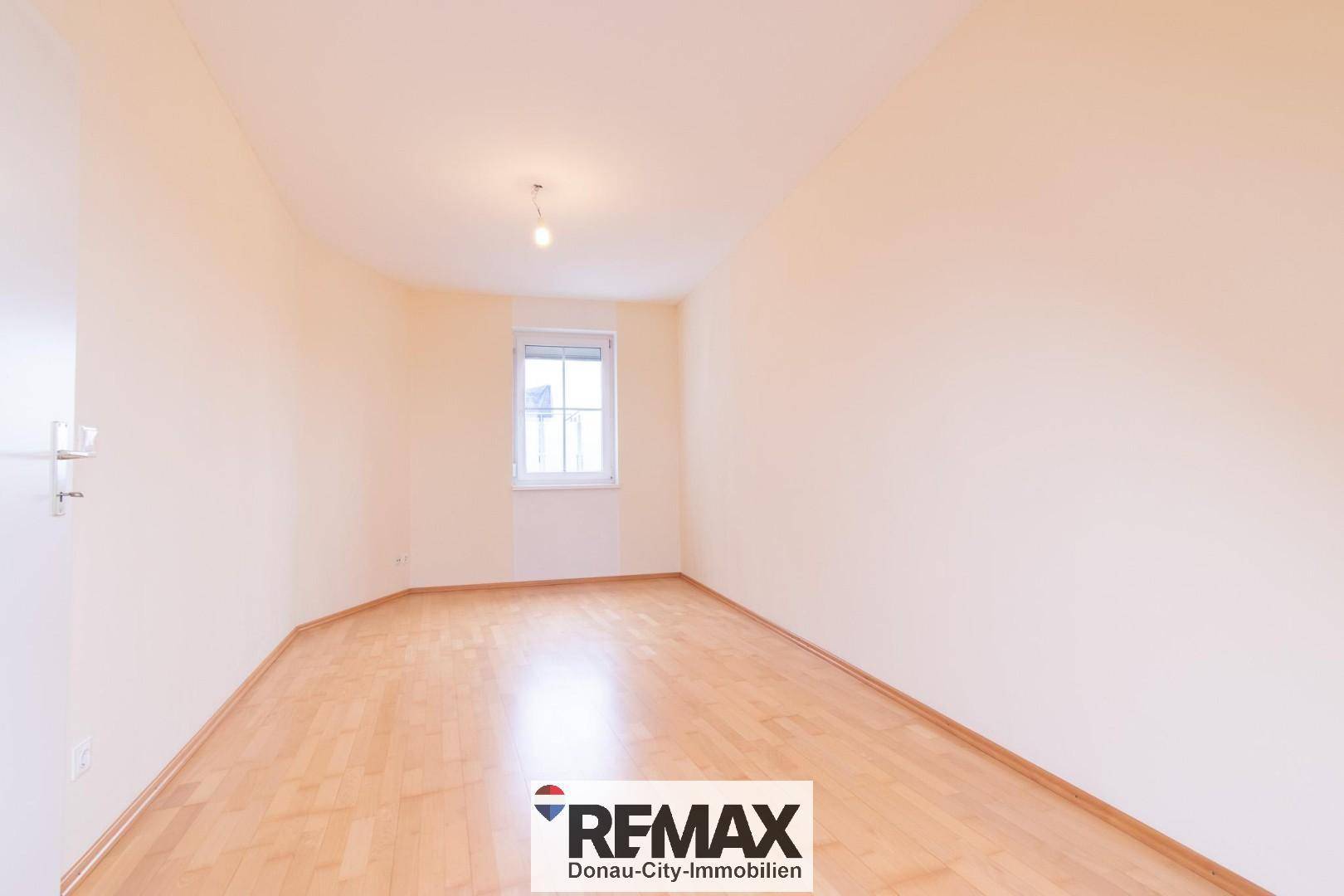 Gemütliches Zimmer mit hellem Holzfußboden und einem Fenster, ideal als Schlaf- oder Arbeitszimmer.
