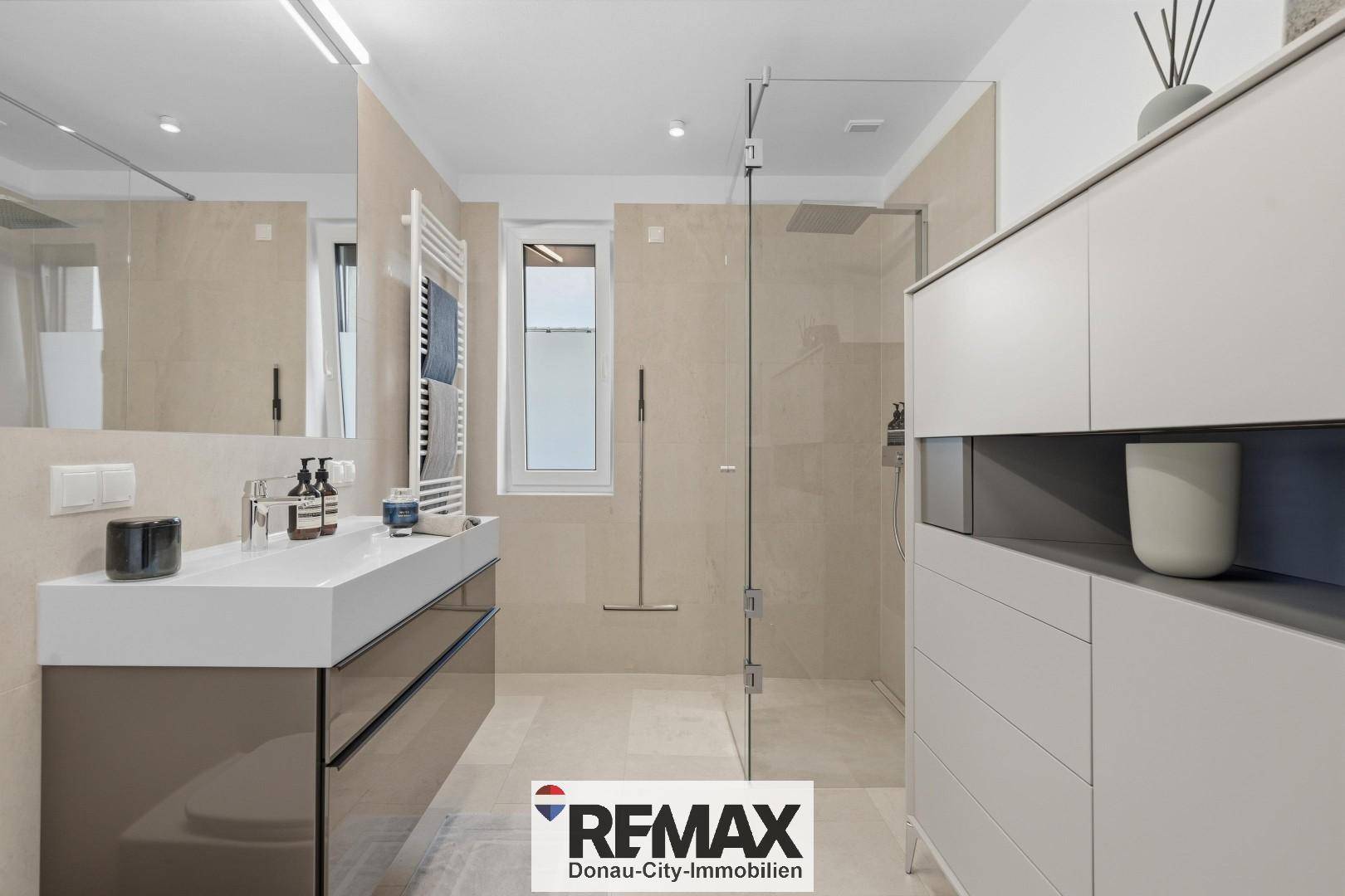Modernes Badezimmer mit begehbarer Dusche, Einzelwaschbecken, beheiztem Handtuchhalter und Fenster.
