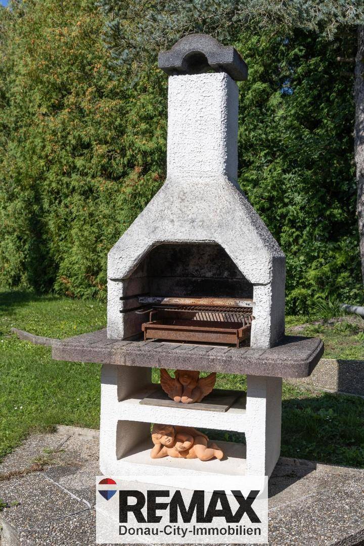 Detailansicht eines gemauerten Grills im Garten, bereit für sommerliche Grillabende.