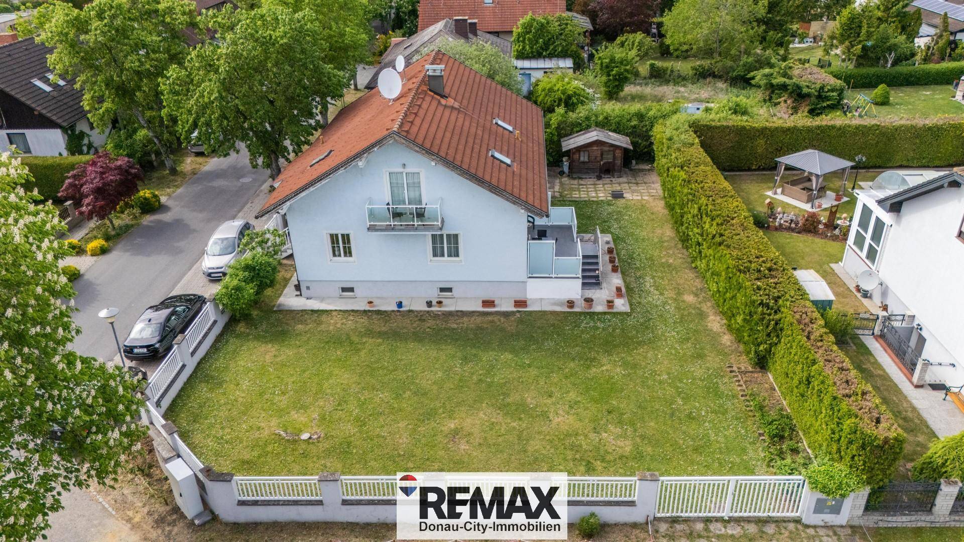 Luftaufnahme des Einfamilienhauses mit großem Garten, umgeben von Wohnbebauung und Grünflächen.