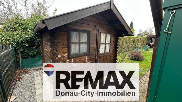 Kleines, rustikales Gartenhaus aus Holz mit Satteldach und Fenstern.