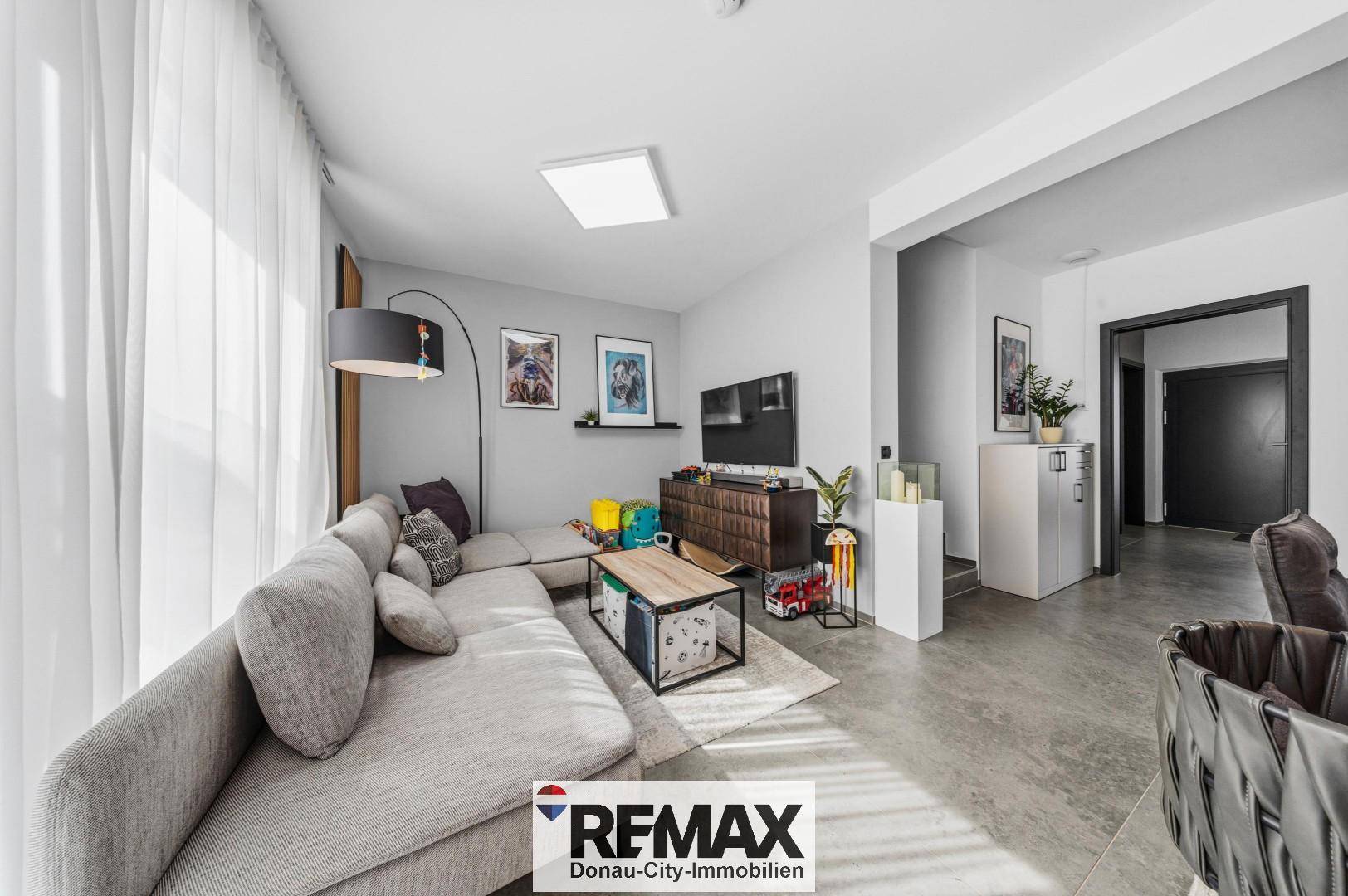 Helles Wohnzimmer mit bequemer Eckcouch, modernem Couchtisch und Blick auf den Flur.