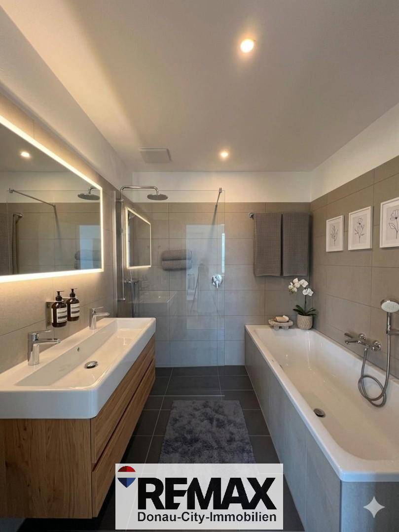 Geräumiges Badezimmer mit Badewanne, begehbarer Dusche und Doppelwaschbecken.