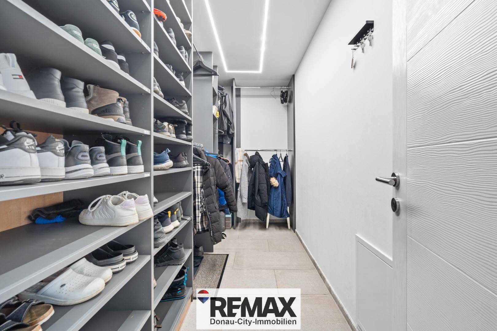 Geräumiger begehbarer Kleiderschrank mit vielen Regalen für Schuhe und Kleidung.
