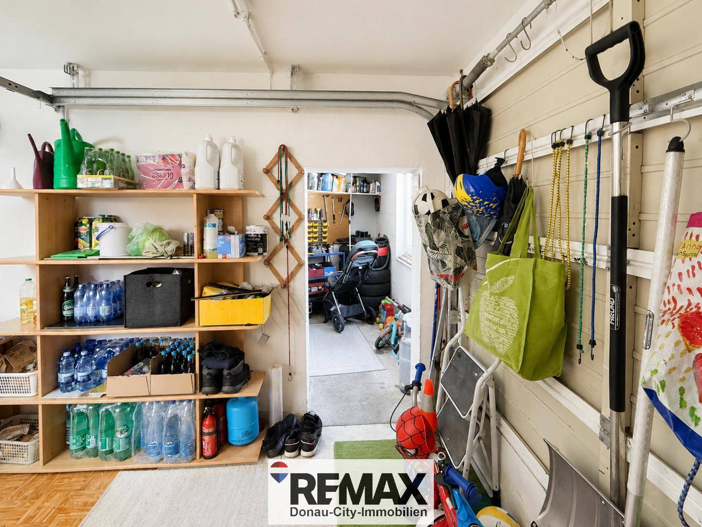 Garage mit Regalen und Haken für Werkzeuge und Haushaltsgegenstände.