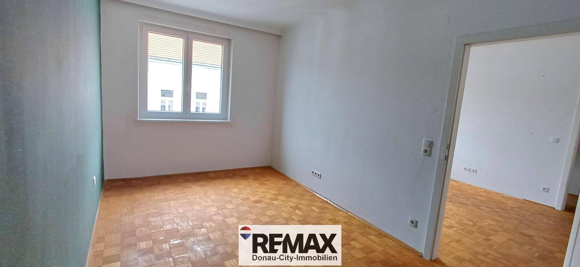 Gemütliches Zimmer mit Parkettboden und einem Fenster, das für natürliche Belüftung sorgt.