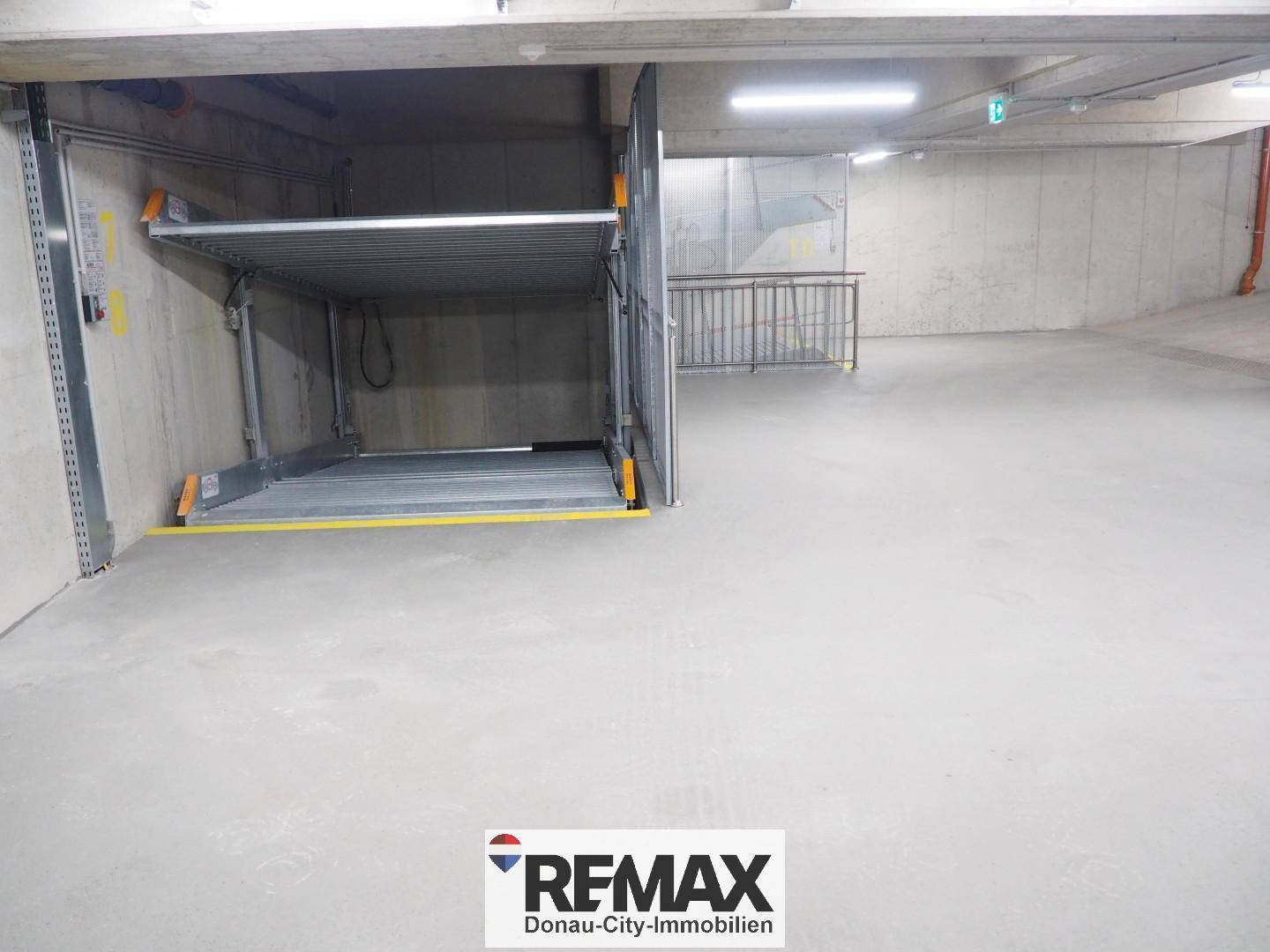 Tiefgarage mit modernem Parksystem für Fahrzeuge, gut beleuchtet.