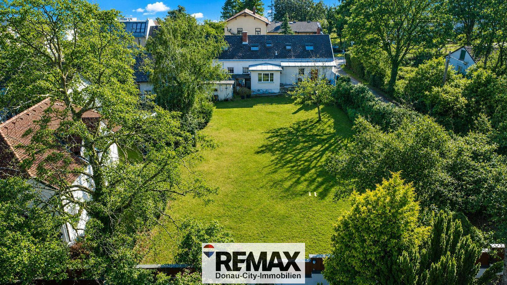 Luftaufnahme eines Einfamilienhauses mit großem Garten und viel Grünfläche.