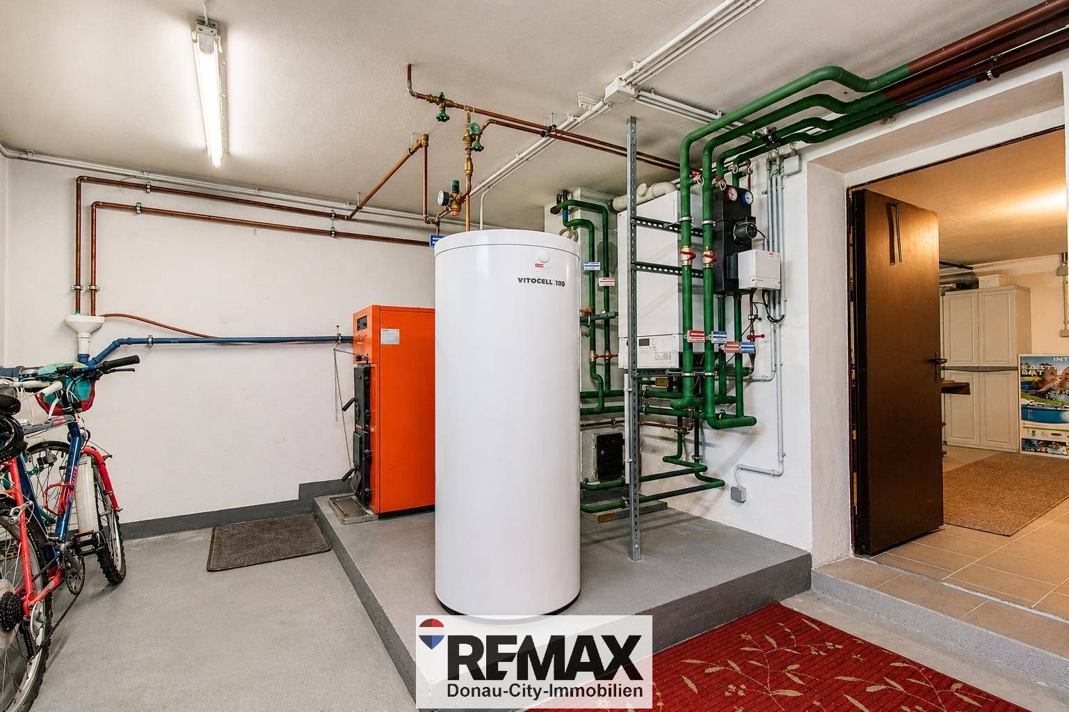 Heizraum im Keller mit moderner Heizungsanlage und Warmwasserspeicher, gut organisiert und funktional.