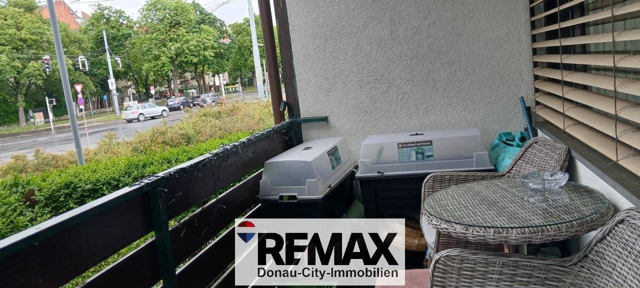 Balkon mit Sitzgelegenheiten und Stauraum, bietet Blick auf die belebte Straße.