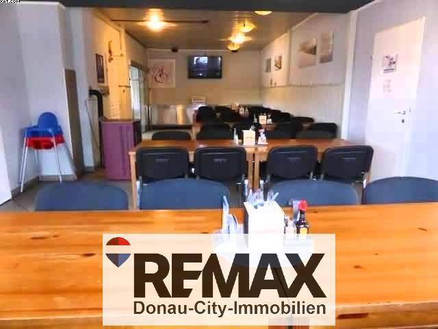 Weiterer Blick in den Gastraum mit Holztischen, Stühlen und einem Kinderhochstuhl, bereit für Gäste.