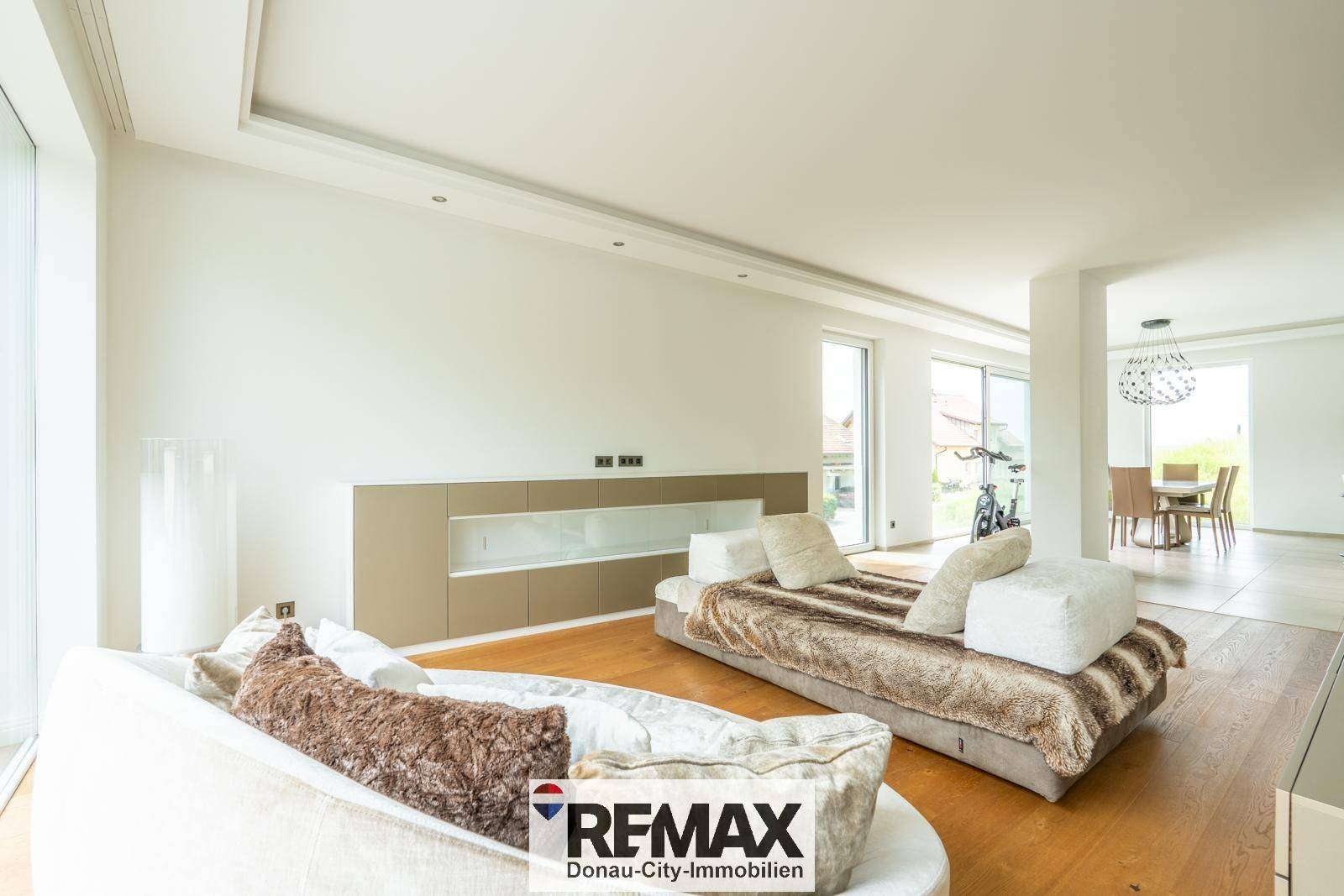 Geräumiges Wohnzimmer mit bequemen Sofas, Holzboden und Blick in den Essbereich.
