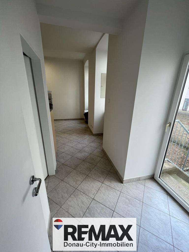 Eingangsbereich mit Fliesenboden und Zugang zu einem Außenbereich.