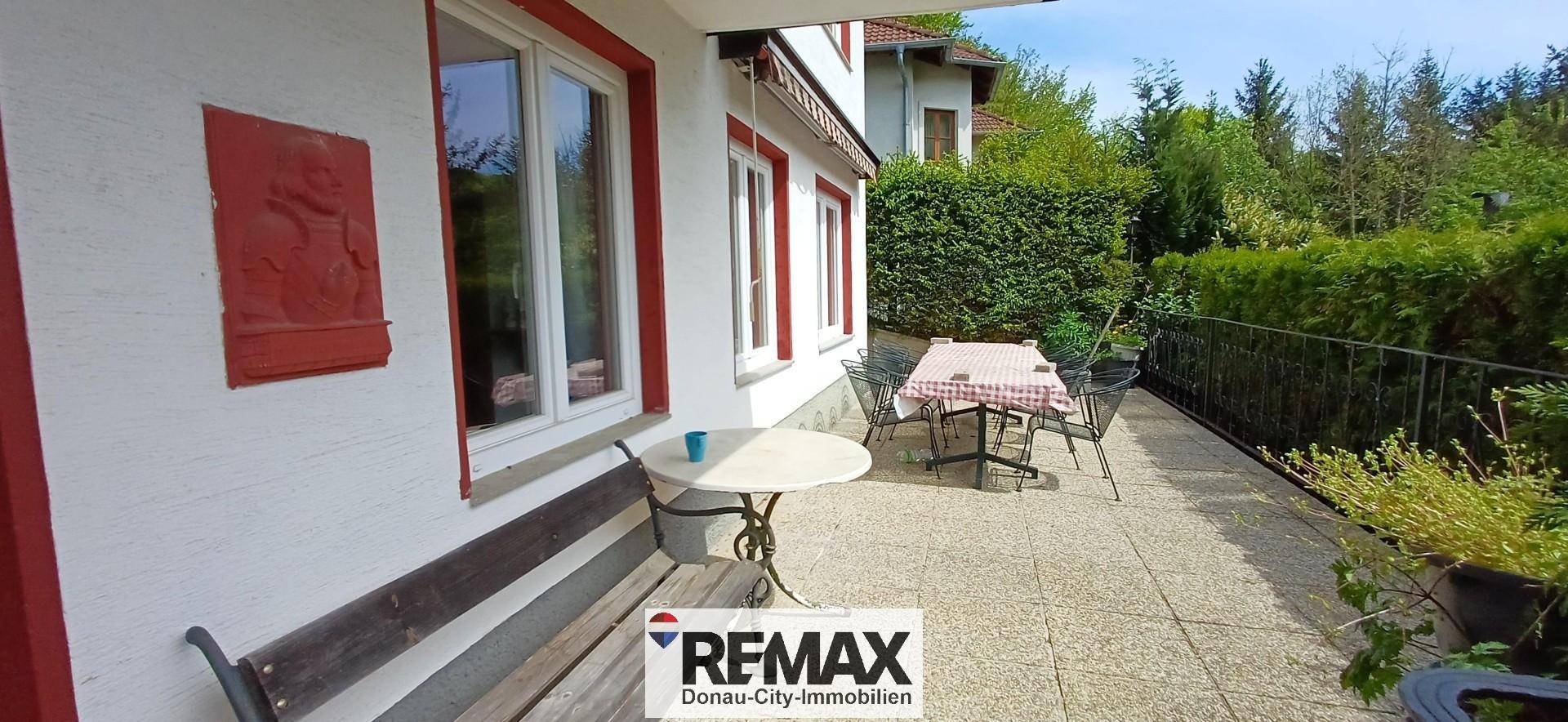 Große gepflasterte Terrasse mit Esstisch und Stühlen, ideal für Mahlzeiten im Freien.