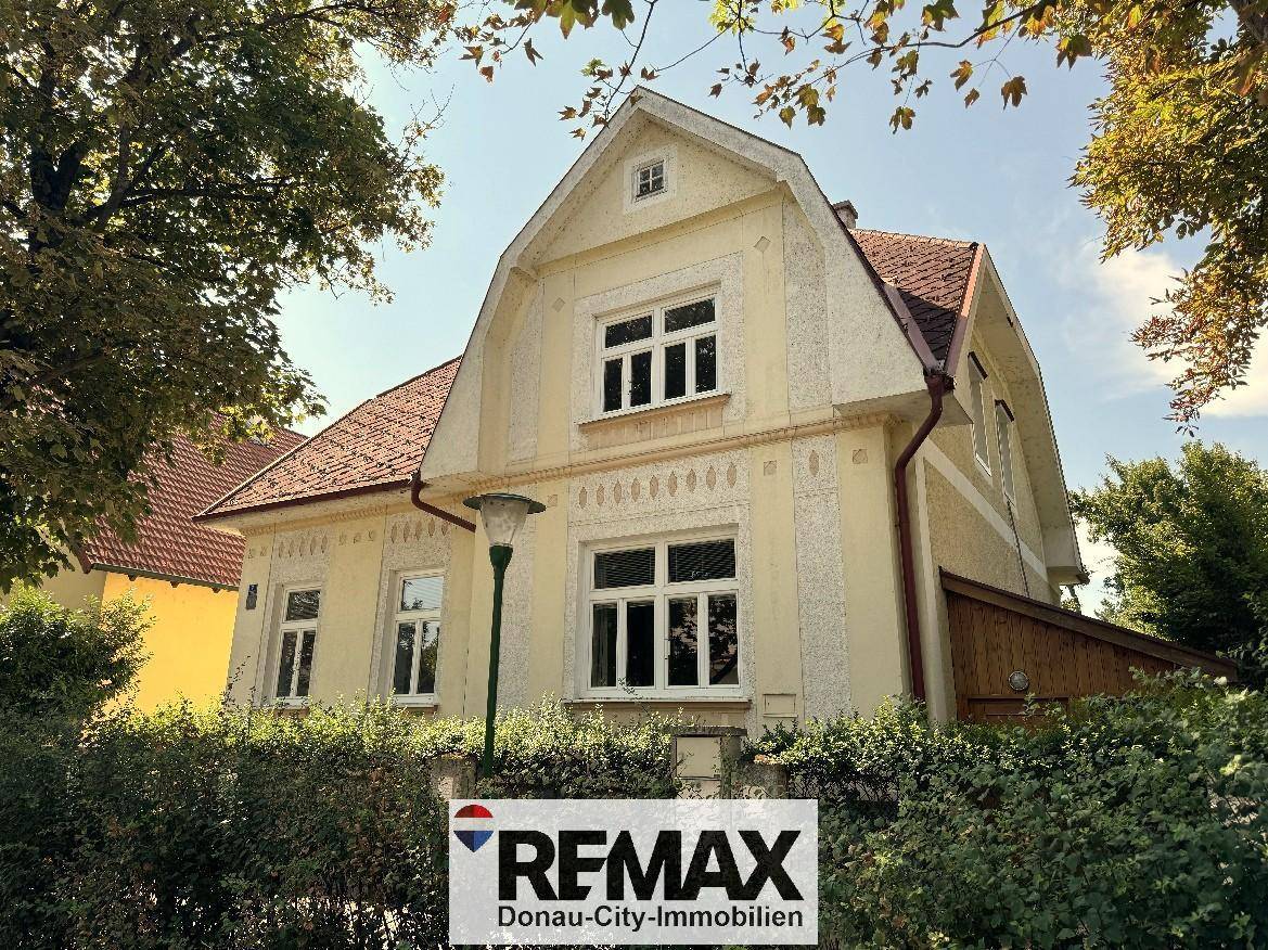 Vorderansicht des Hauses von der Straße, mit Giebeldach und dekorativer Fassadengestaltung.